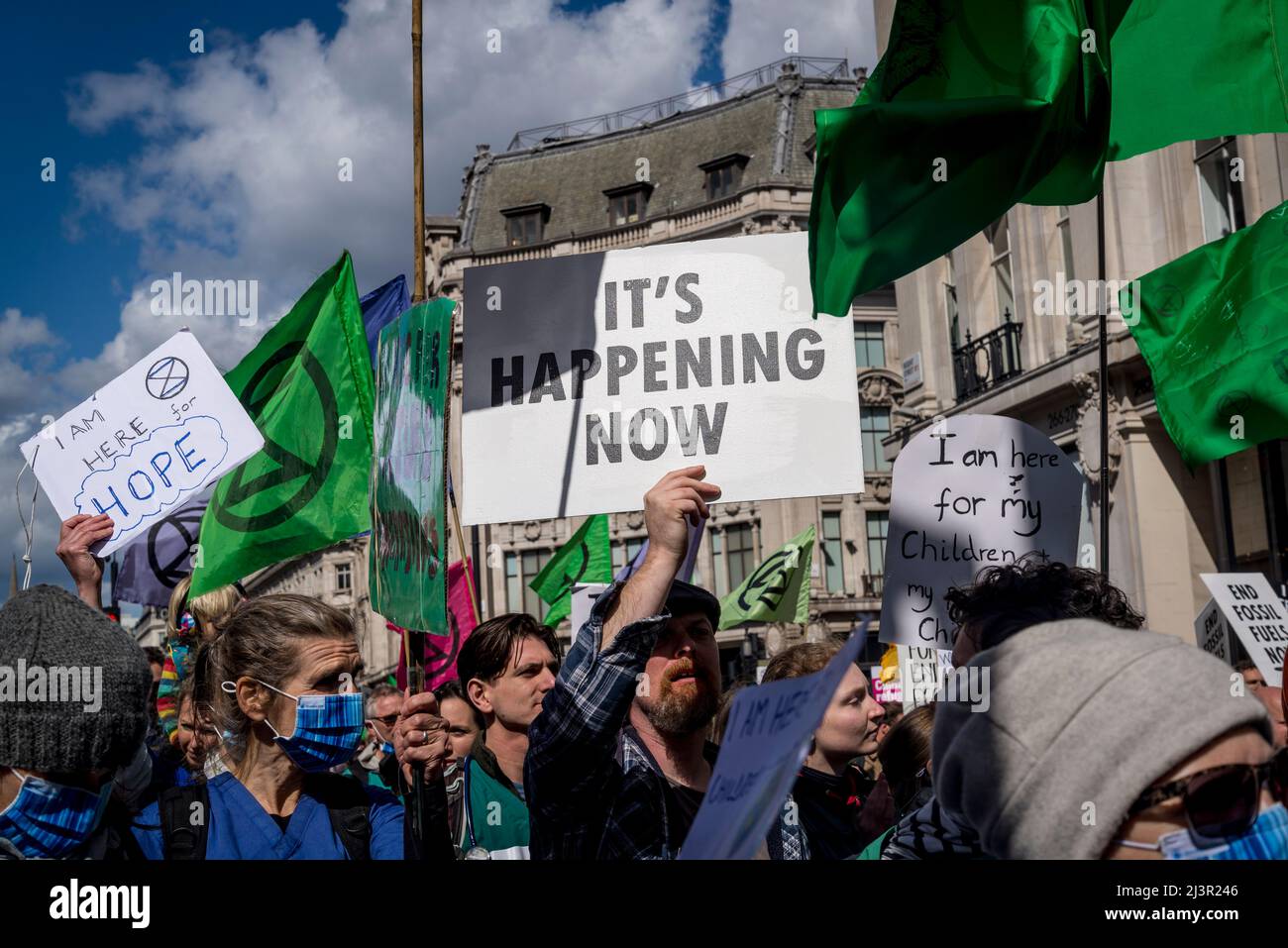 Sta accadendo ora placard, non saremo spettatori, una protesta della ribellione di estinzione che combatte per la giustizia climatica, nel centro di Londra, 09.04.2022, Londra, Inghilterra, REGNO UNITO Foto Stock
