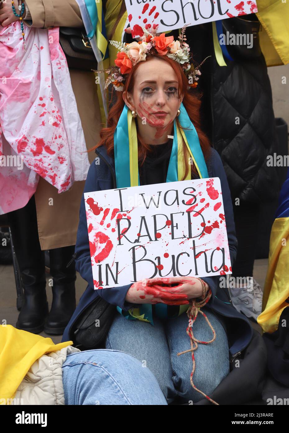 Londra, Inghilterra, Regno Unito 9 aprile 2022 Stand with Ucraina protesta e morire-in Downing Street. I manifestanti indossavano costumi tradizionali e portavano cartelli con dichiarazioni sui crimini commessi dai soldati russi e giacevano con le mani legate e incatenate. Foto Stock