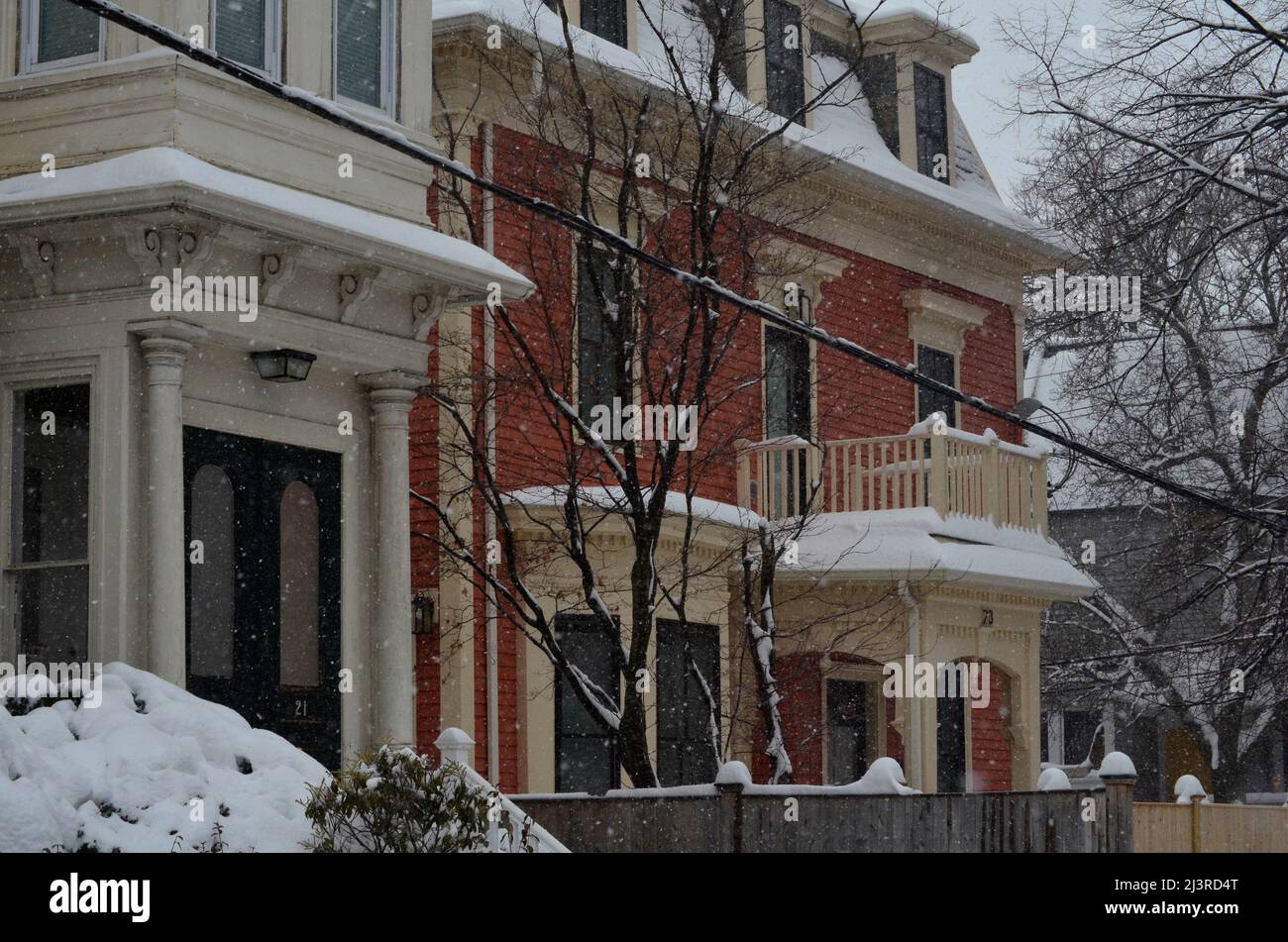 Ambientazione invernale a Cambridge, Massachusetts, con la neve che copre i tetti di case e automobili. Foto Stock