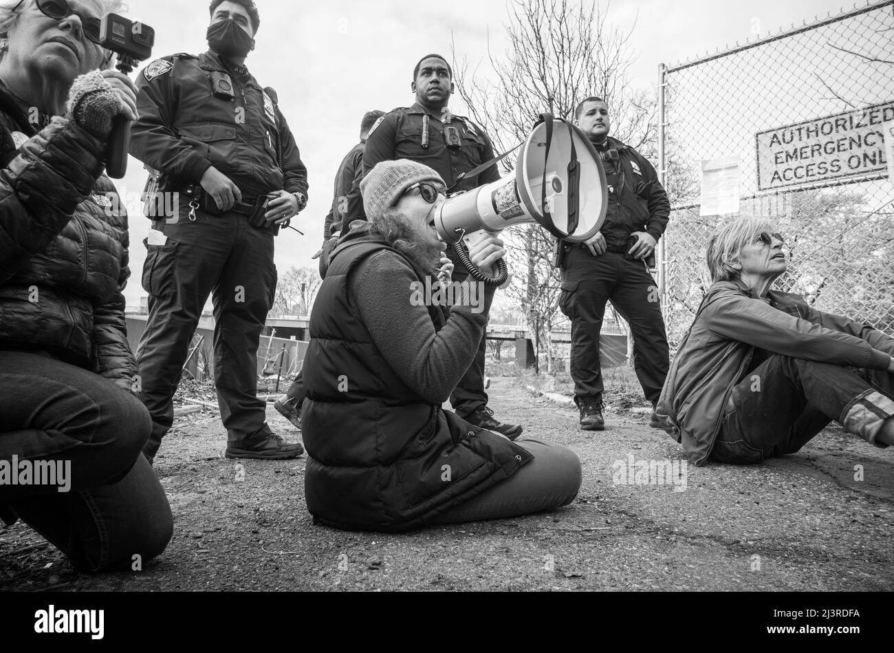 New York, New York, Stati Uniti. 9th Apr 2022. SARAH WELLINGTON, a sinistra e altri attivisti bloccano un ingresso ai Parchi Corlears Hook che arrestano gli sforzi della città per rimuovere rami potati dagli alberi degli aerei di Londra nel parco di New York City. I due "difensori della terra" precedenti sono stati arrestati dopo aver avvolto le braccia intorno a un albero di ciliegi che impedivano agli appaltatori della città di rimuovere e potare gli alberi nel parco."le comunità e i protettori della terra stanno chiedendo ai parchi di New York City di bloccare tutti i permessi di lavoro sugli alberi per il piano del Dipartimento di progettazione e costruzione". Ha detto Wellington. (Credit Image: © Fr Foto Stock