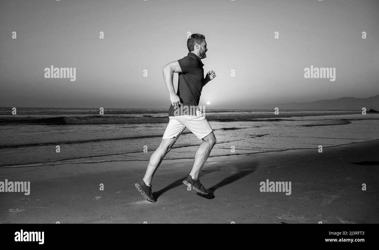 attività di allenamento mattutina. uomo sano che corre sulla spiaggia all'alba. estate energica. Foto Stock