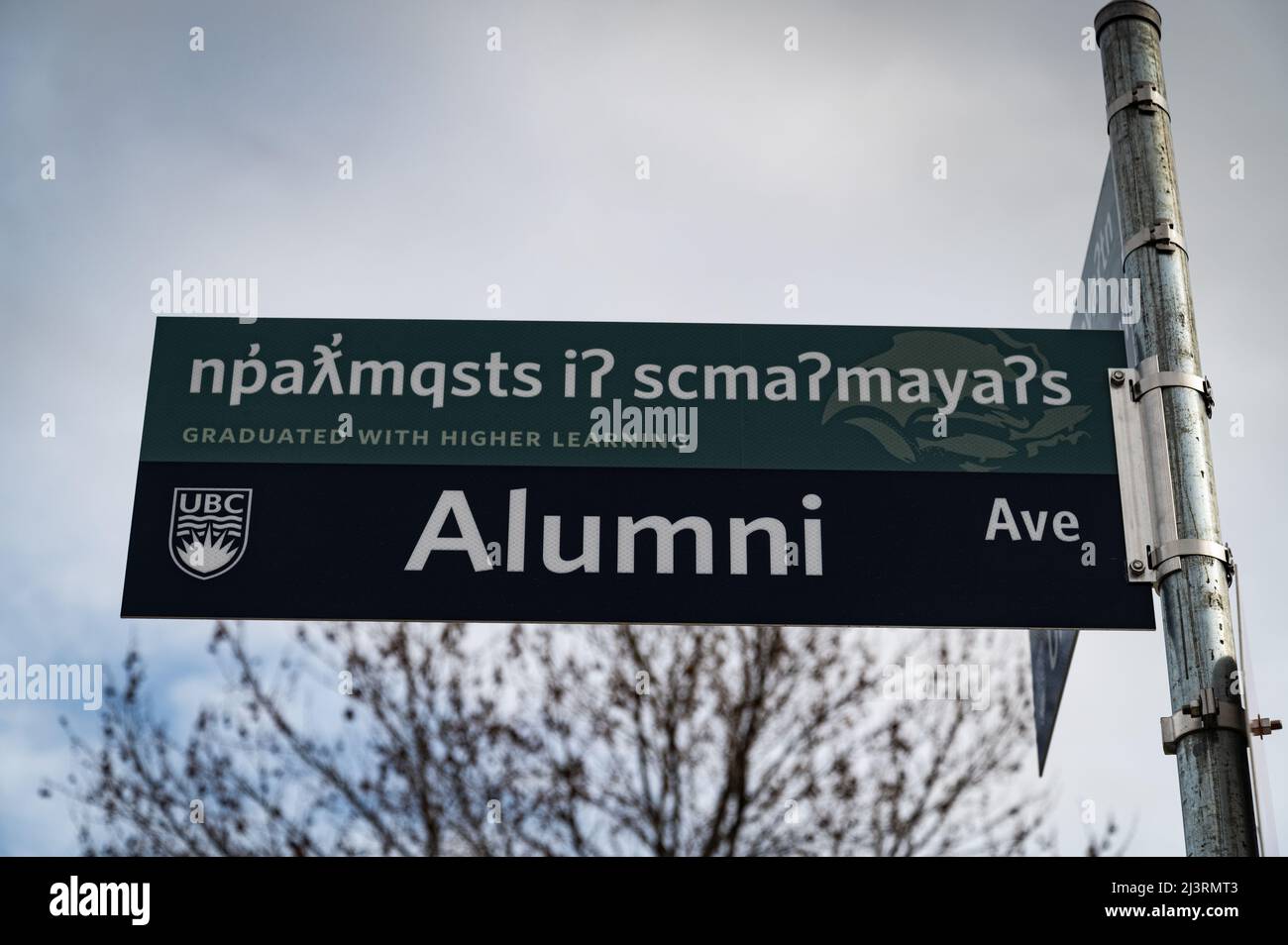 Foto di un cartello stradale degli ex allievi, tradotto in Nsyilxcn, lingua della nazione Syilx Okanagan, sul cui territorio si trova il campus Okanagan di UBC. Foto Stock