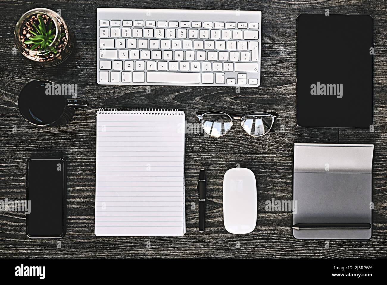 La tecnologia wireless rende il lavoro aziendale. Scatto ad angolo elevato di una vasta gamma di dispositivi wireless su una scrivania. Foto Stock