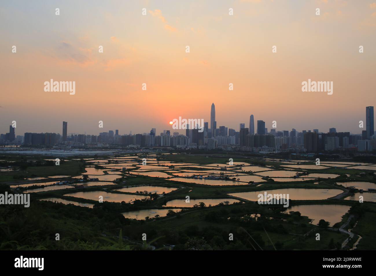 Skyline di Shenzhen , con grattacieli e uffici contro la fattoria di pesce o stagni di pesce, durante il momento drammatico in serata, dalla vista del confine di Hong K. Foto Stock
