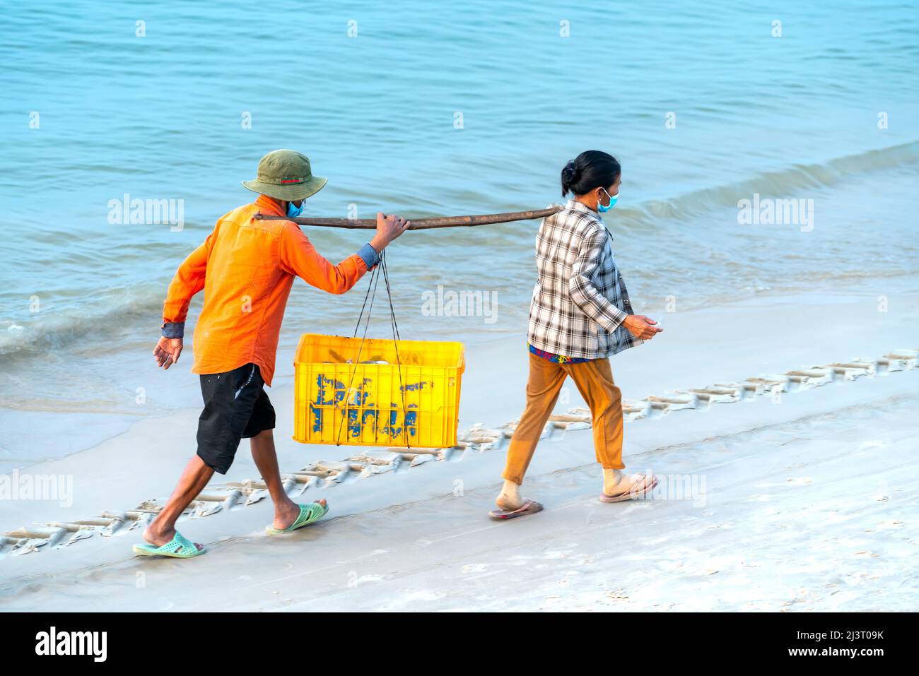 Sessione di mercato del pesce mari, la gente si è riunita all'interno della vendita del pesce del cestino, i pescatori di canottaggio strenui hanno portato il villaggio di pesca della riva a Phan Thiet Foto Stock