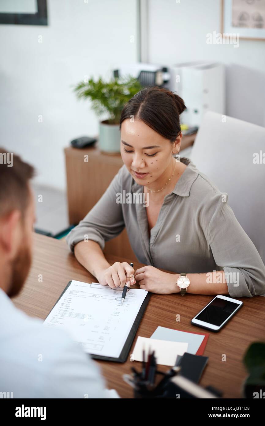 Si prega di leggere questo documento. Shot di una donna d'affari che legge attraverso un contratto con un cliente. Foto Stock