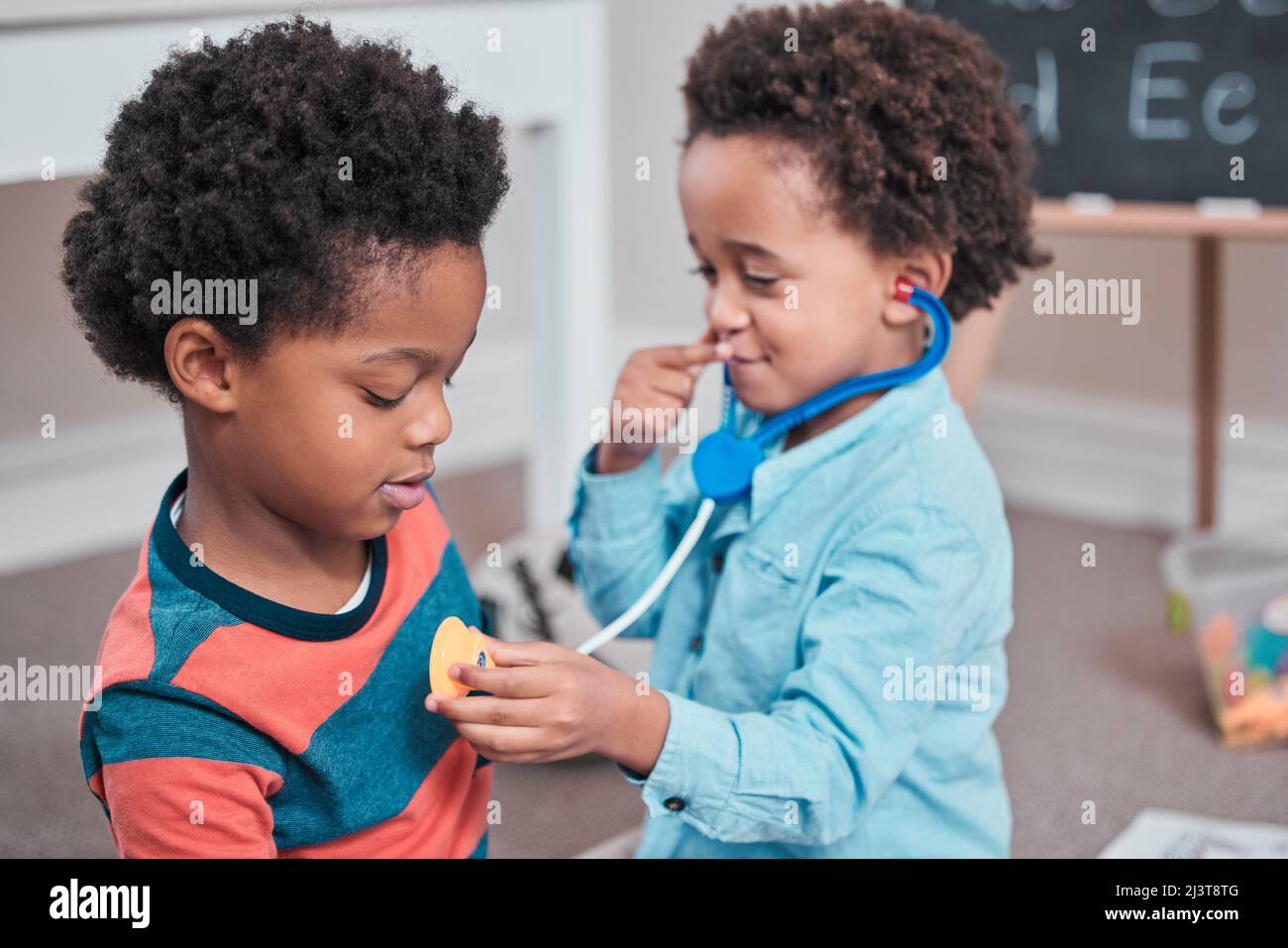Malato sia il medico e youre il mio paziente. Colpo di un ragazzo usando uno stetoscopio giocattolo sul suo. Foto Stock