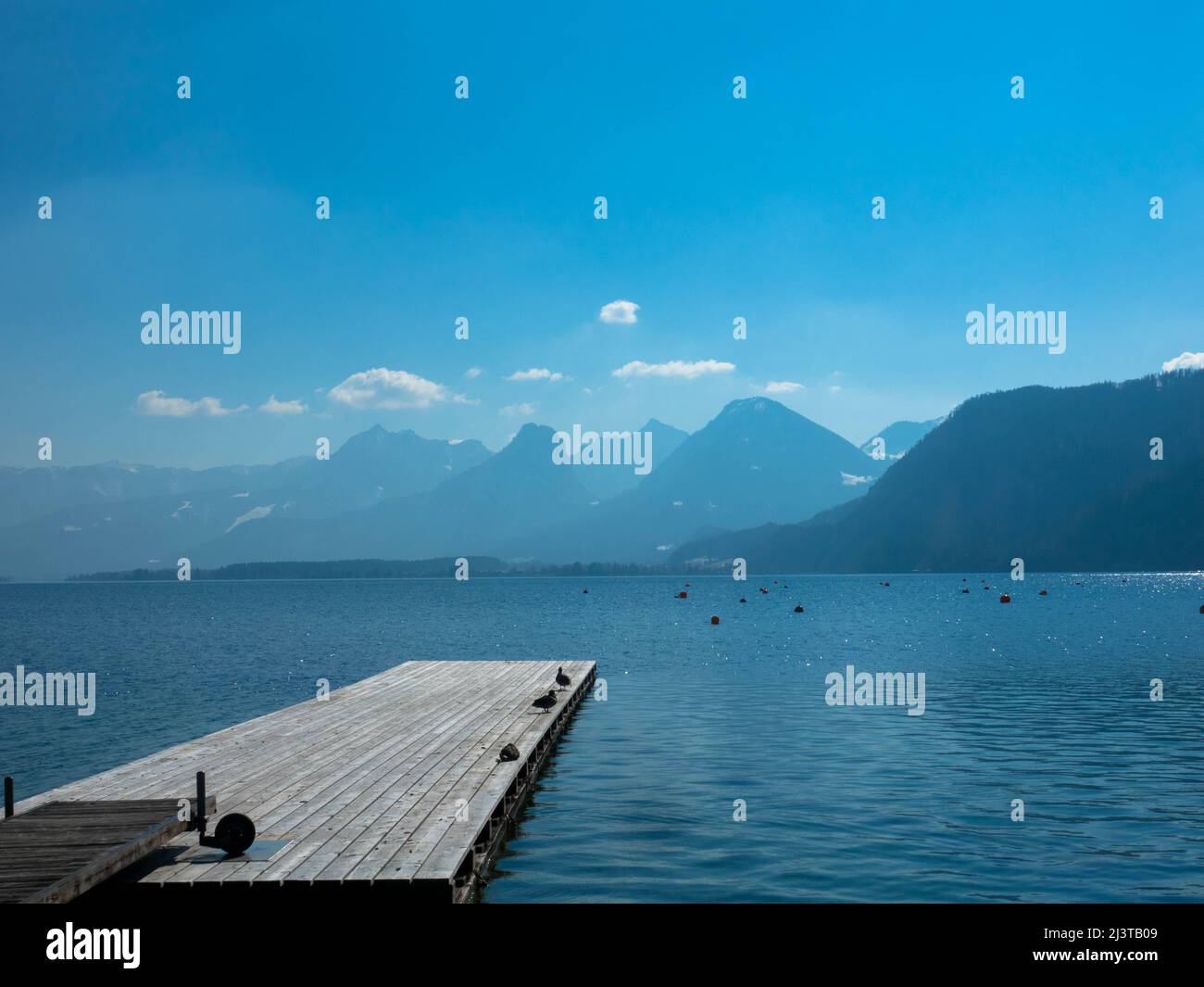 Vista panoramica di un lago australiano con molo in legno e catena montuosa sullo sfondo. Salzkammergut Austria superiore Foto Stock