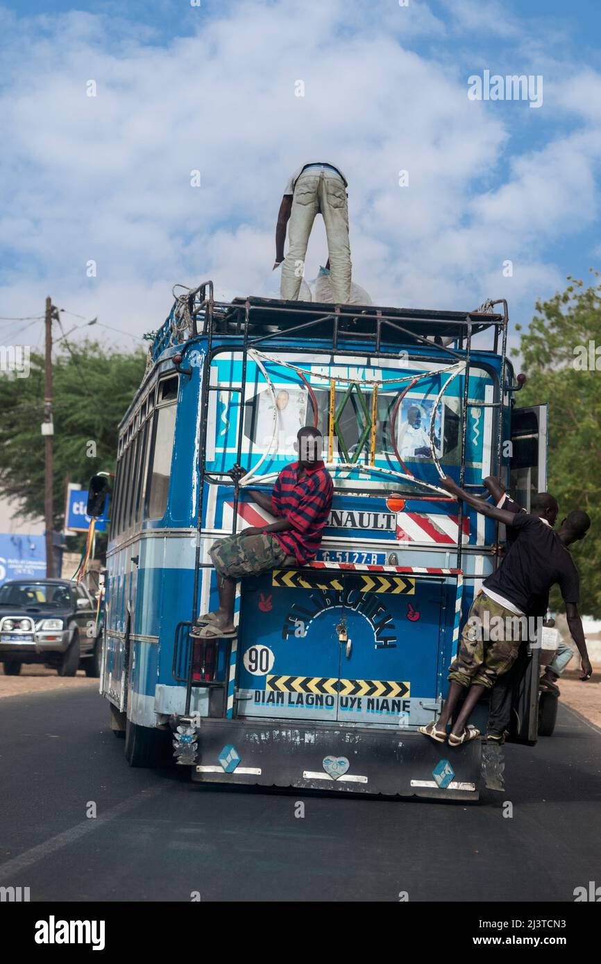 Senegal, sicurezza stradale. Passeggeri che viaggiano alla fine dell'autobus, o in cima. Qui non ci sono cinture di sicurezza! Foto Stock