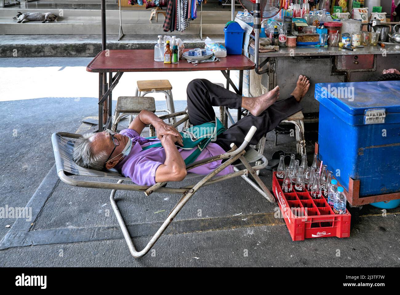 Mid day nap sia per uomo che per cane. Uomo e animale dormono all'aperto in strada Foto Stock