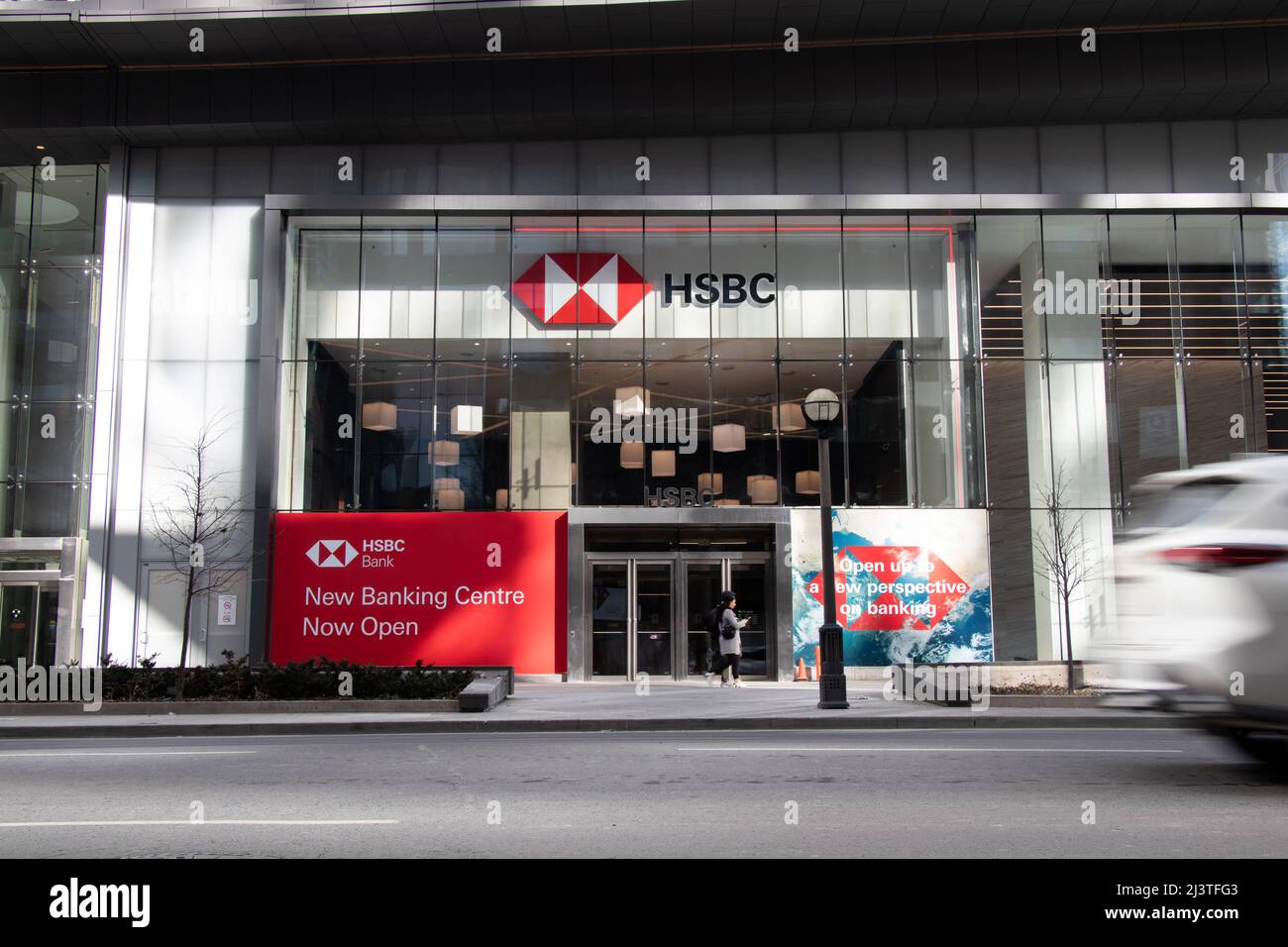 La parte anteriore di una nuova filiale della banca di HSBC è vista nel centro di Toronto, mentre il traffico passa vicino. Foto Stock