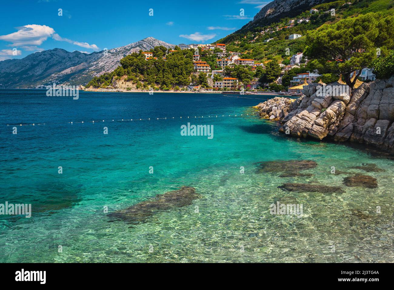 Bella spiaggia ghiaiosa e posti fantastici con case mediterranee sul mare, Brela, Dalmazia, Croazia, Europa Foto Stock