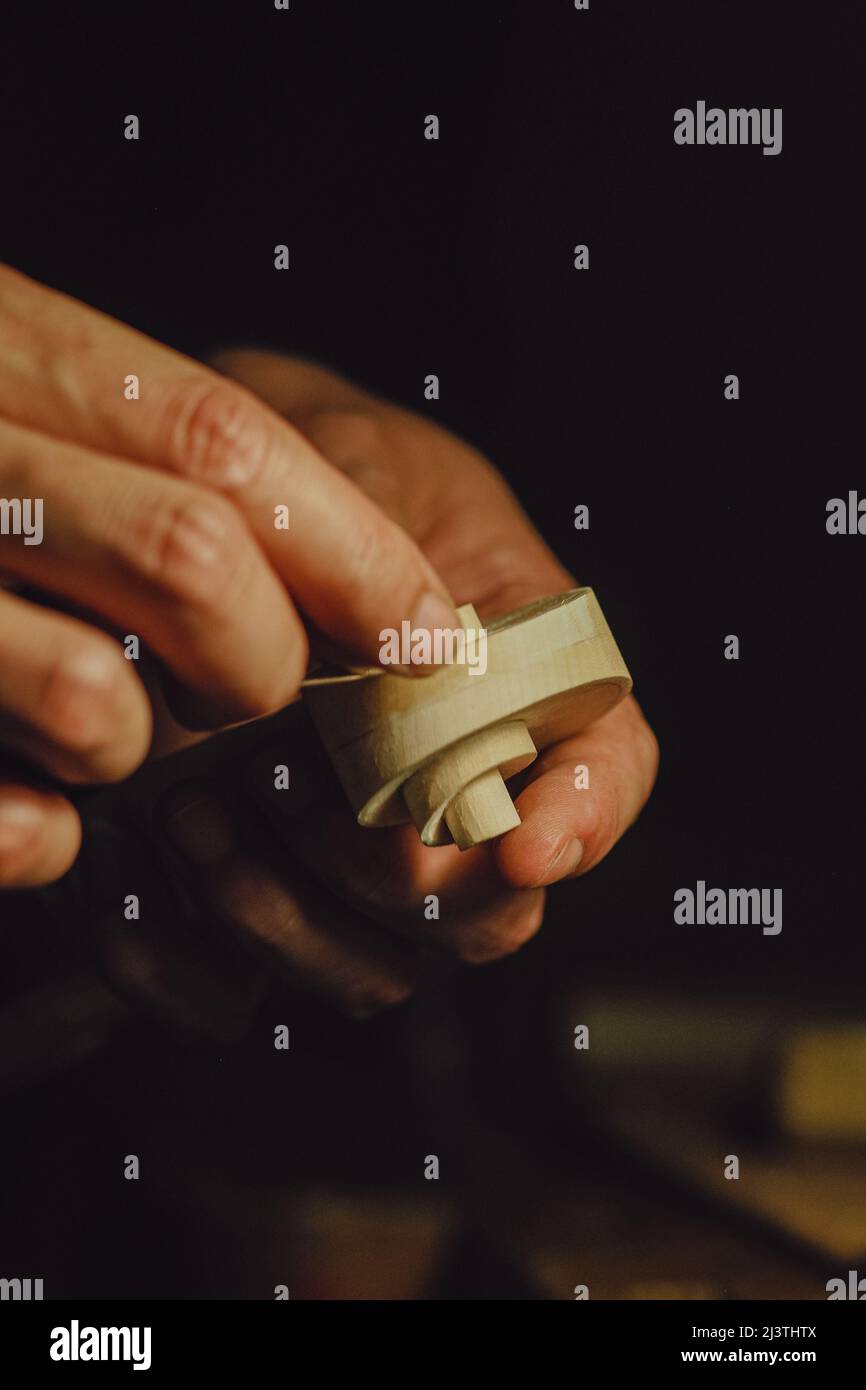 artigian scolpendo un rotolo di violino - luthier al lavoro concetto Foto Stock