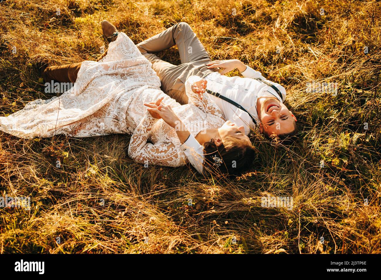 Felice giovane coppia sdraiata sull'erba in autunno. Ambiente romantico Foto Stock