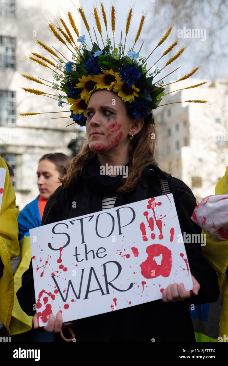 Londra, Regno Unito. 9th Apr 2022. Centinaia di ucraini simulano la loro morte in un muoio con le mani legate dietro le spalle e le donne dipingono il sangue sul loro volto per protestare contro l'invasione russa in corso dell'Ucraina di fronte Downing Street. Foto Stock