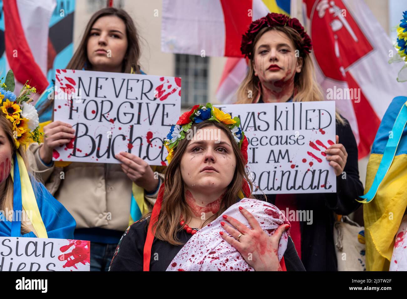 I manifestanti che hanno fatto un moriboire, facendo riferimento ai civili ucraini uccisi in città come Bucha durante la guerra con la Russia. Femmine con bambino 'morto' Foto Stock