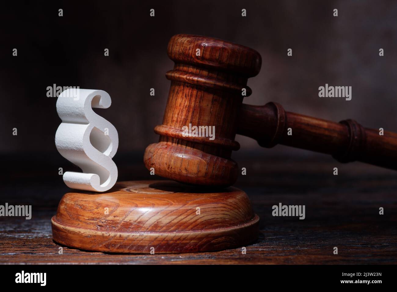 Giudici in legno Gavel e simbolo di legge e giustizia sul tavolo in un tribunale o ufficio di polizia su sfondo scuro Foto Stock