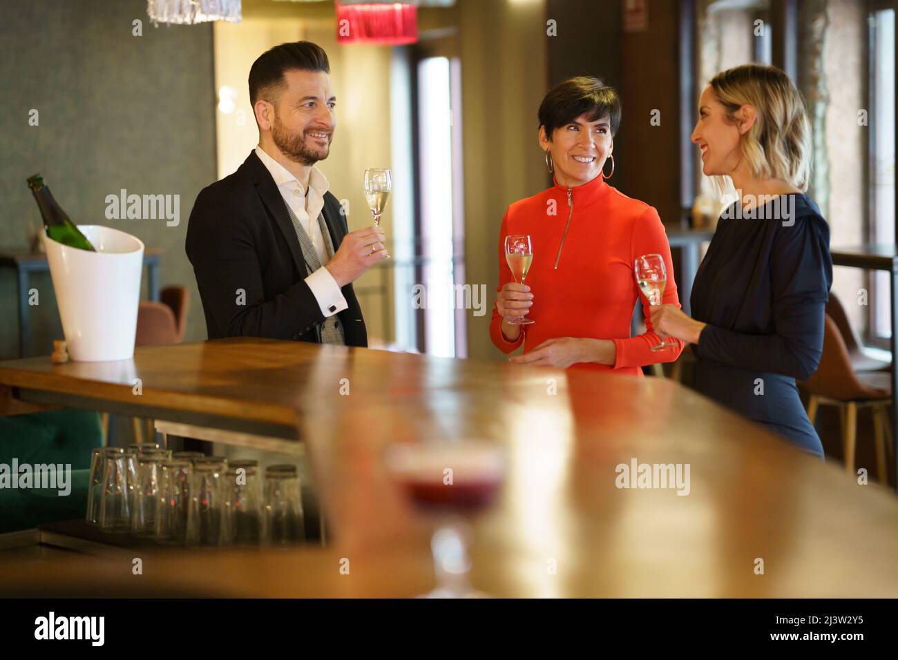 Compagnia di persone che bevono champagne al ristorante Foto Stock