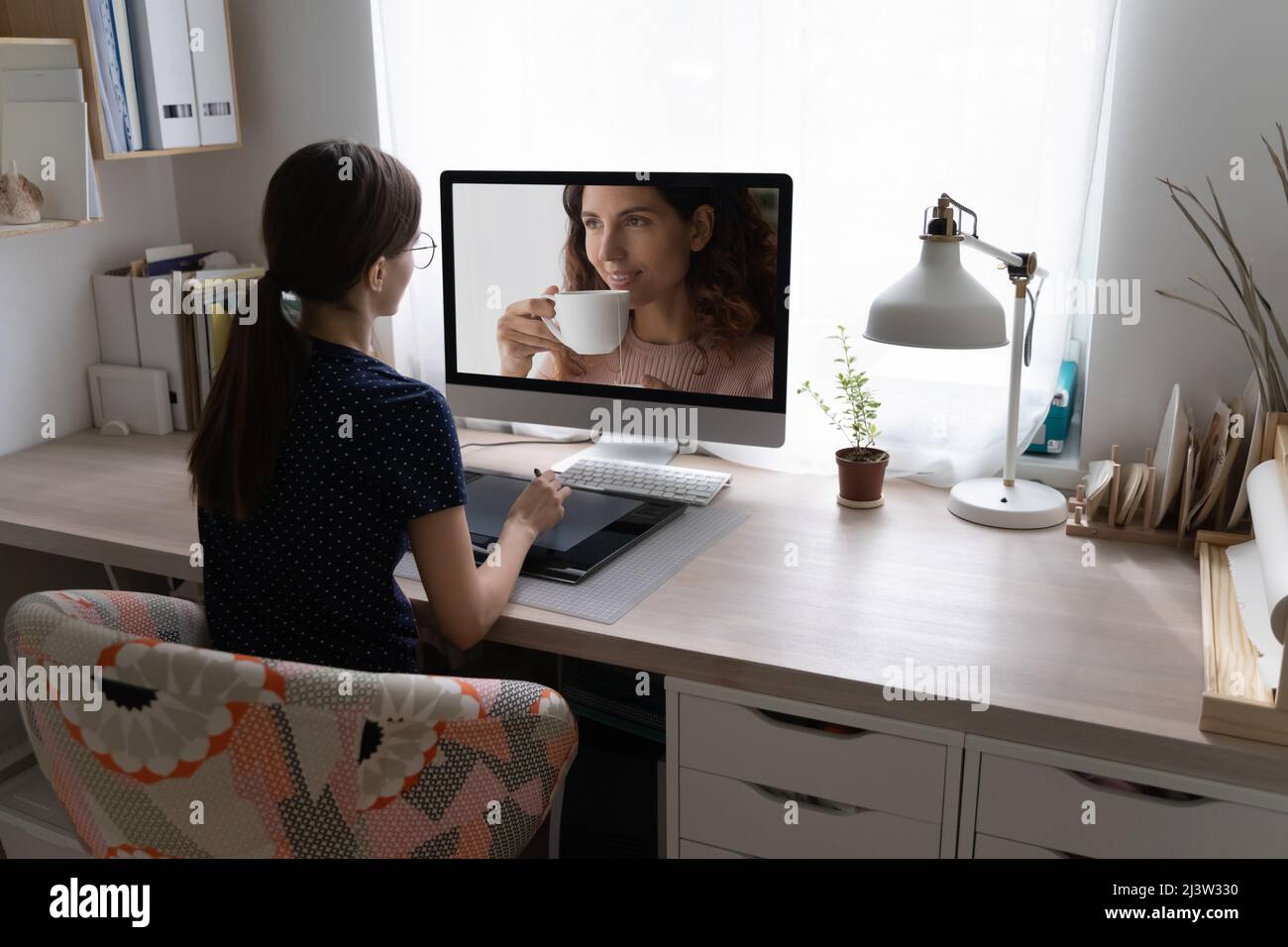 Le fotografi femminili utilizzano un tablet grafico digitale, fanno ritoccare la fotografia Foto Stock