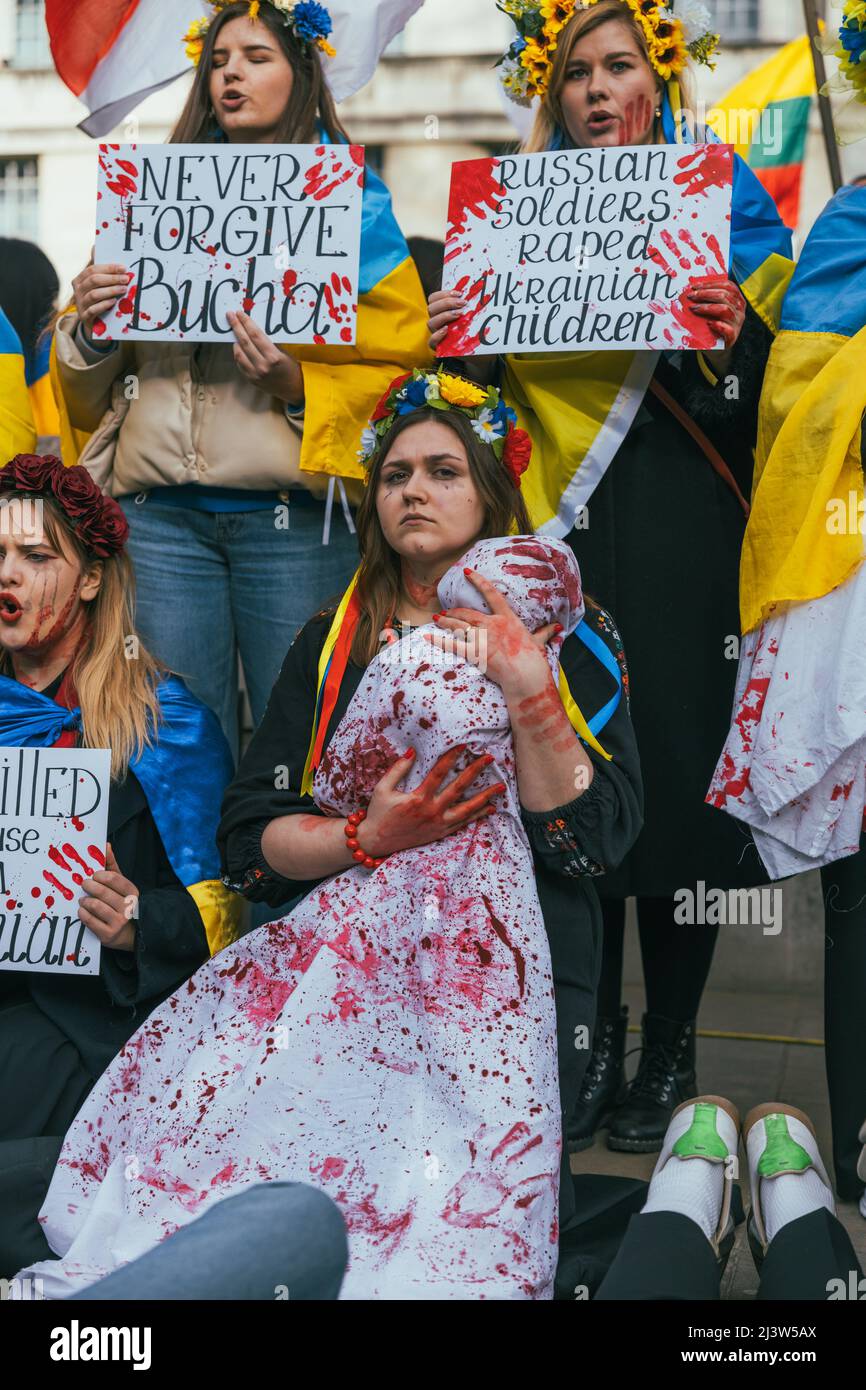 La donna Ucraina protesta contro la guerra ucraino-russa tenendo un bambino coperto di sangue. Dimostrazione pro-Ucraina, stand con l'Ucraina Foto Stock