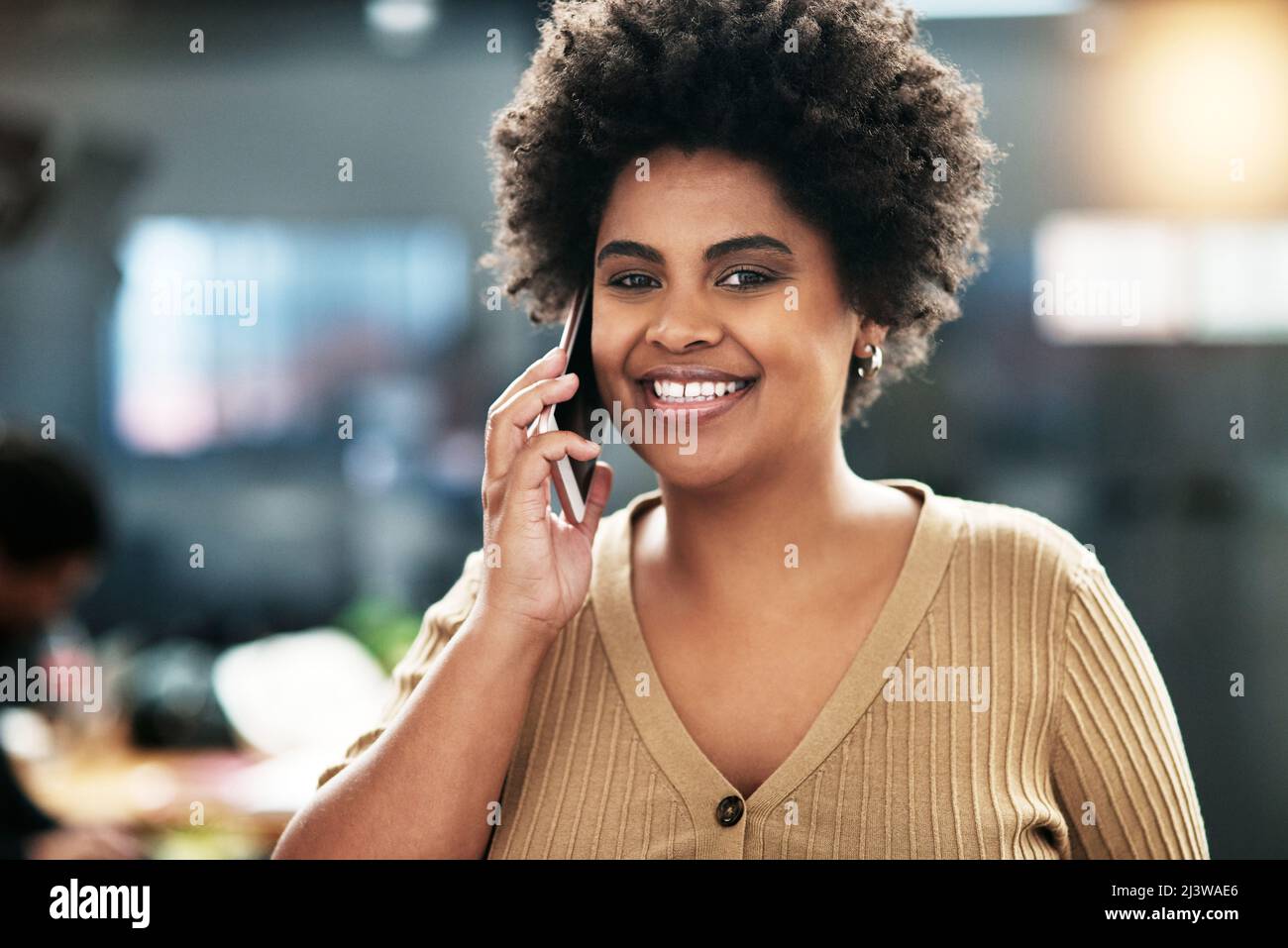 Non ti conosci adesso. Shot di una giovane donna d'affari attraente in piedi in ufficio e utilizzando il suo cellulare. Foto Stock