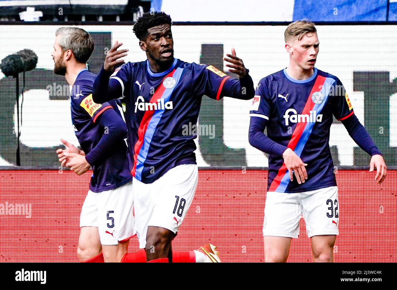 Kiel, Germania. 10th Apr 2022. Calcio: 2nd Bundesliga, Holstein Kiel - Hamburger SV, Matchday 29, Holstein Stadium. Kwasi Okyere Wriedt di Kiel (centro) celebra il suo obiettivo per le 1:0 tra Stefan Thesker di Kiel (l) e Jonas Sterner di Kiel. Credit: Axel Heimken/dpa - NOTA IMPORTANTE: In conformità con i requisiti della DFL Deutsche Fußball Liga e della DFB Deutscher Fußball-Bund, è vietato utilizzare o utilizzare fotografie scattate nello stadio e/o della partita sotto forma di immagini di sequenza e/o serie di foto video-simili./dpa/Alamy Live News Foto Stock