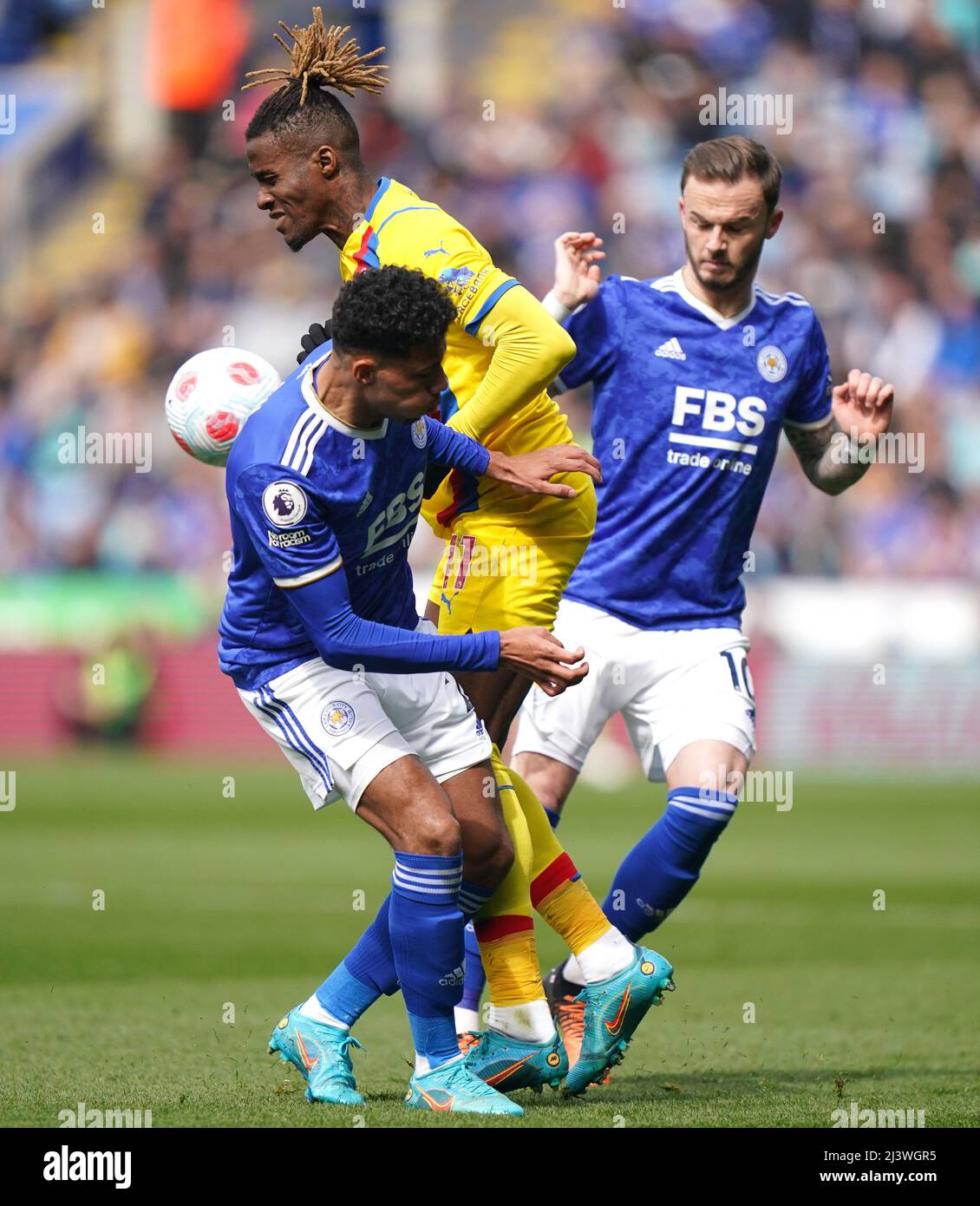 Wilfried Zaha (centro) del Crystal Palace e James Maddison (destra) di Leicester City e James Justin combattono per la palla durante la partita della Premier League al King Power Stadium di Leicester. Data foto: Domenica 10 aprile 2022. Foto Stock