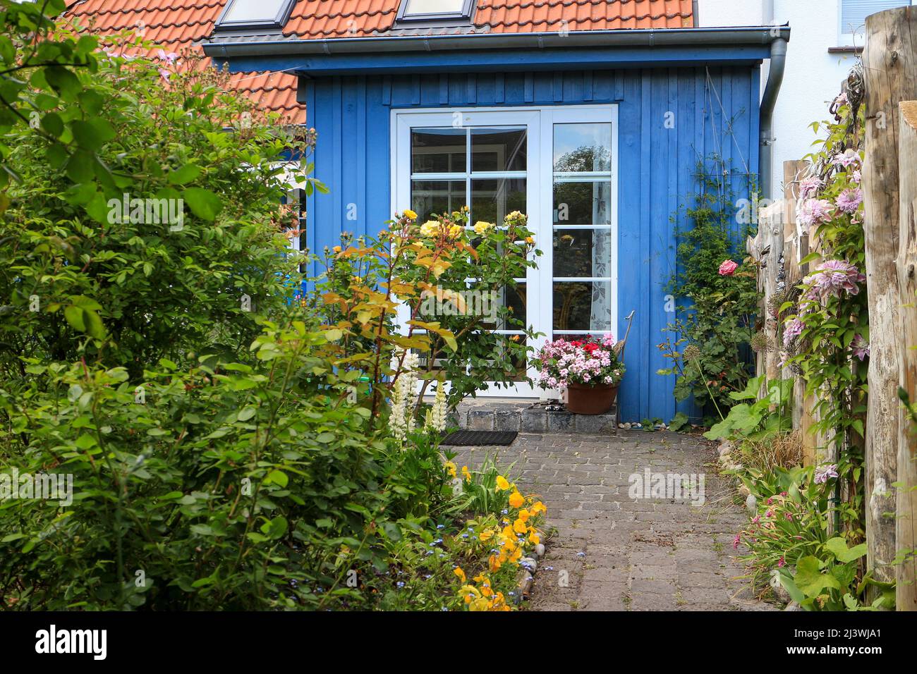 Percorso giardino che conduce ad una capanna di legno o rifugio Foto Stock
