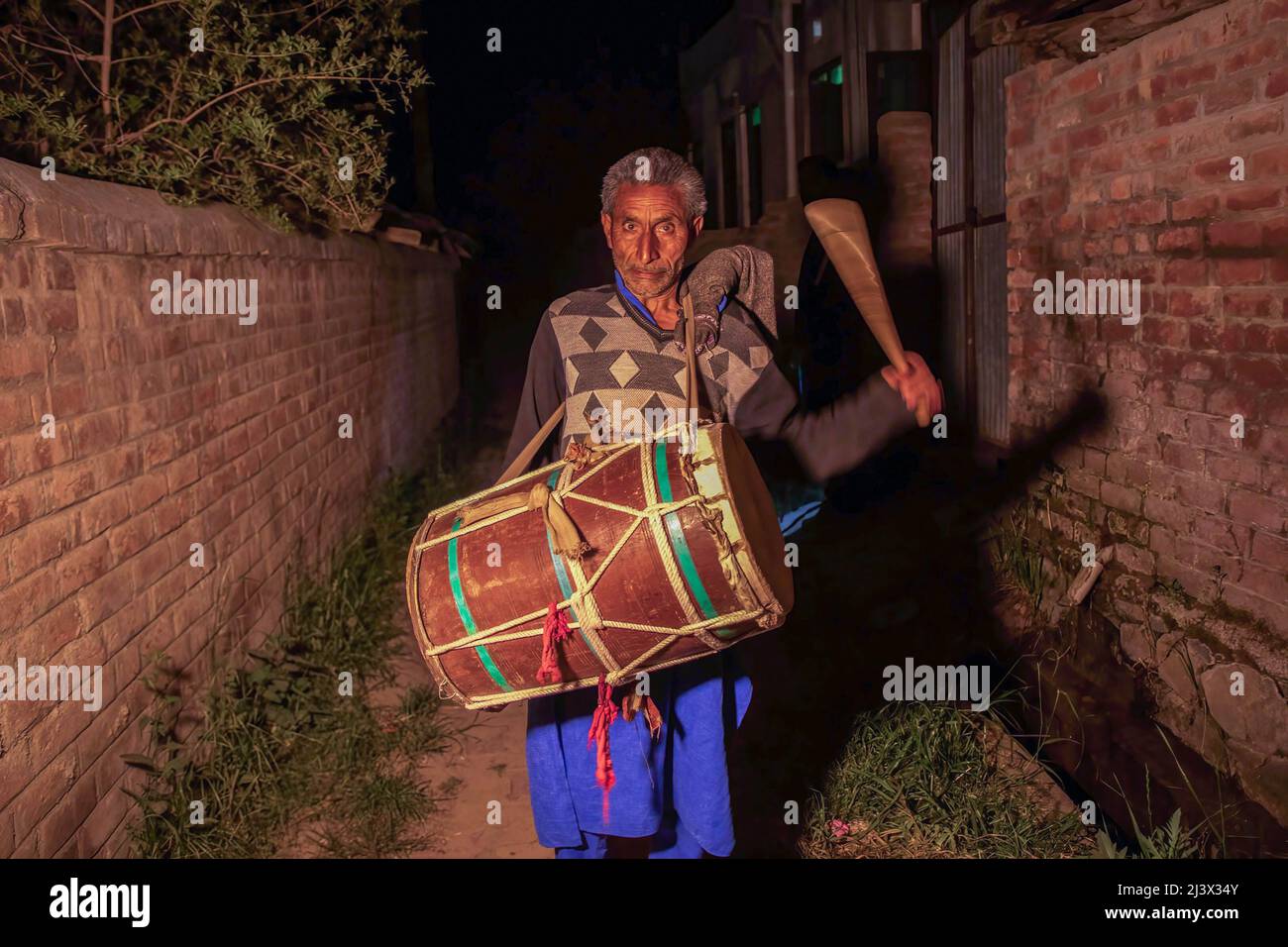 Ali Mohammad 55, un batterista di Kashmiri Ramadan o un allarme umano localmente noto come “Sahar Khan”, scopa il tamburo mentre cammina attraverso i vicoli bui nella periferia di Srinagar Kashmir (che ritiene sia un lavoro di corsa a causa della violenza in corso e di decenni di conflitto nella regione contesa), Allertando i residenti musulmani di svegliarsi per i pasti prima dell’alba (Sehri) prima dell’inizio del digiuno del giorno seguente durante il mese santo del Ramadan. (Foto di Faisal Bashir / SOPA Images/Sipa USA) Foto Stock