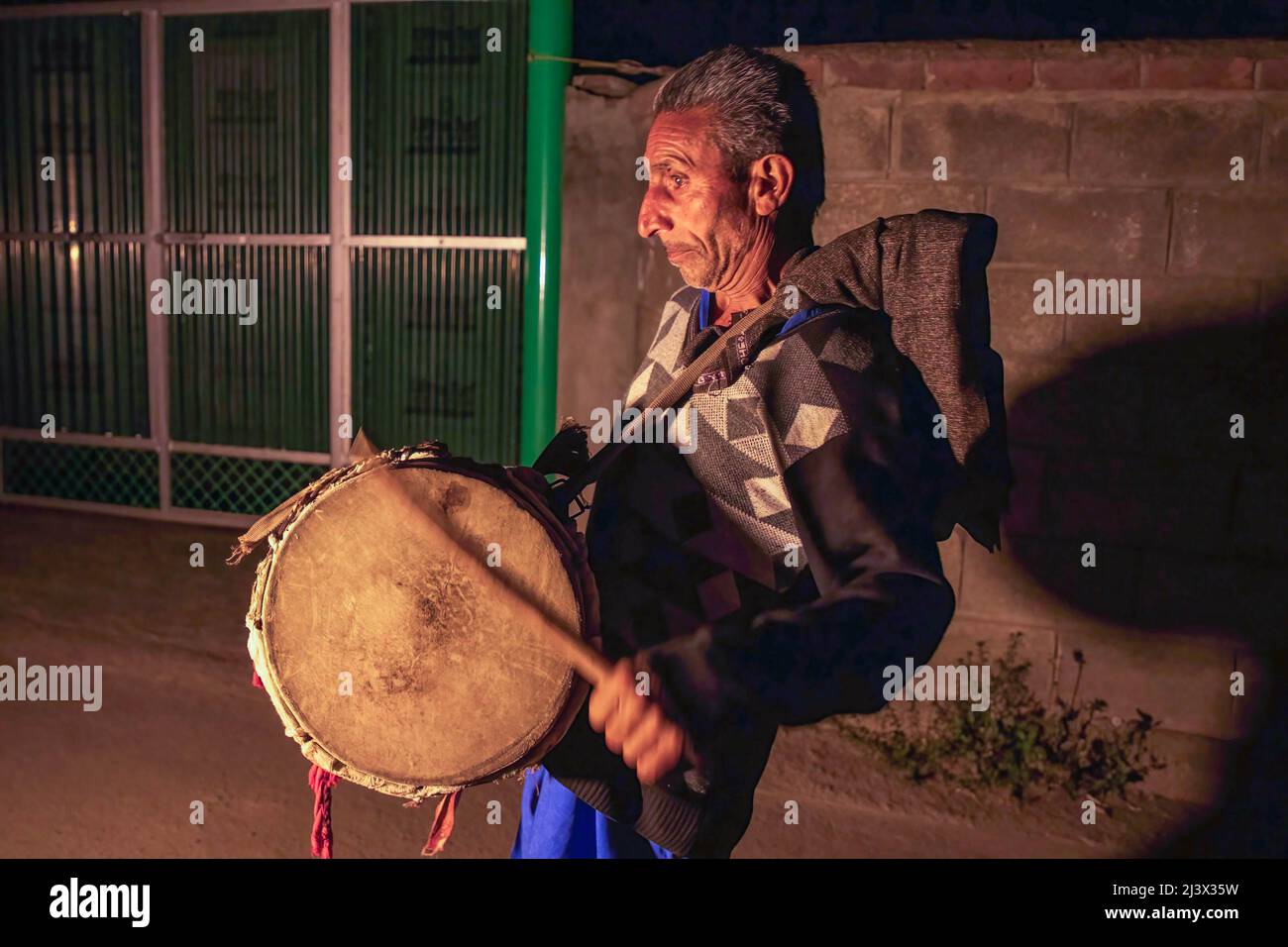 Ali Mohammad 55, un batterista di Kashmiri Ramadan o un allarme umano localmente noto come “Sahar Khan”, scopa il tamburo mentre cammina attraverso i vicoli bui nella periferia di Srinagar Kashmir (che ritiene sia un lavoro di corsa a causa della violenza in corso e di decenni di conflitto nella regione contesa), Allertando i residenti musulmani di svegliarsi per i pasti prima dell’alba (Sehri) prima dell’inizio del digiuno del giorno seguente durante il mese santo del Ramadan. (Foto di Faisal Bashir / SOPA Images/Sipa USA) Foto Stock