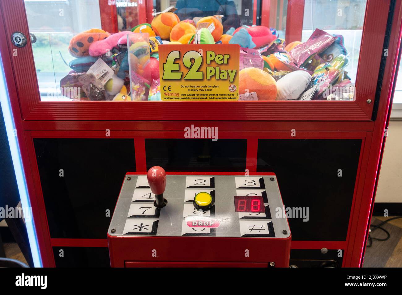 Un gioco di artiglio o gru pieno di attraenti giocattoli farciti colorati. Foto Stock