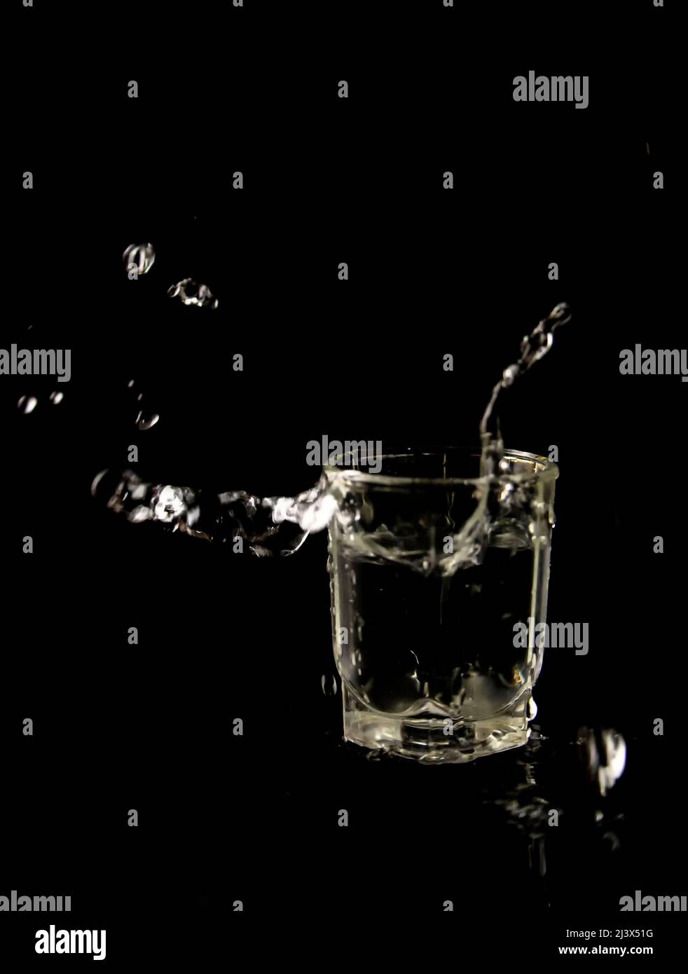 Bicchiere con gocce d'acqua su sfondo nero Foto Stock