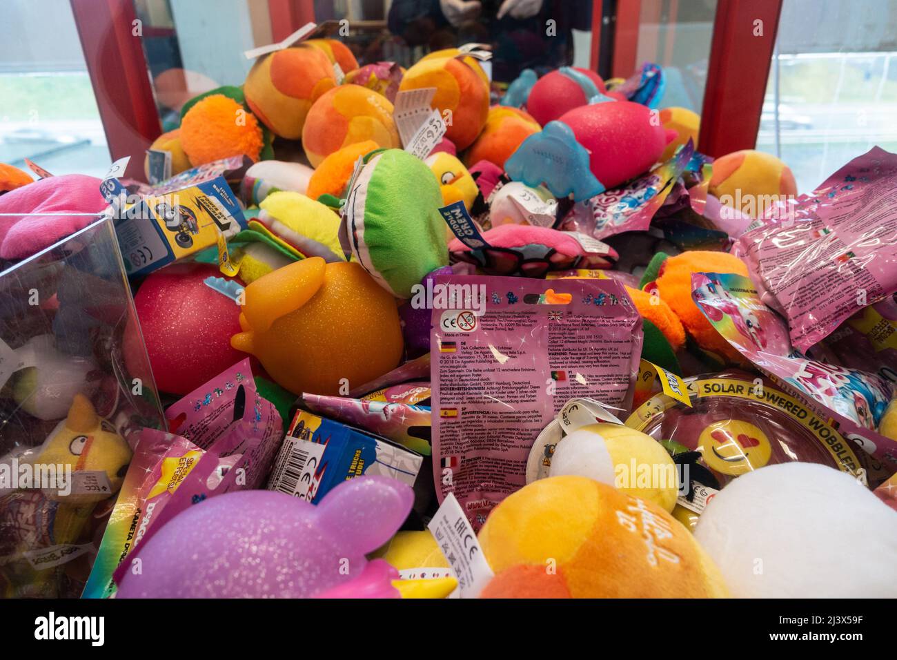 Un gioco di artiglio o gru pieno di attraenti giocattoli farciti colorati. Foto Stock