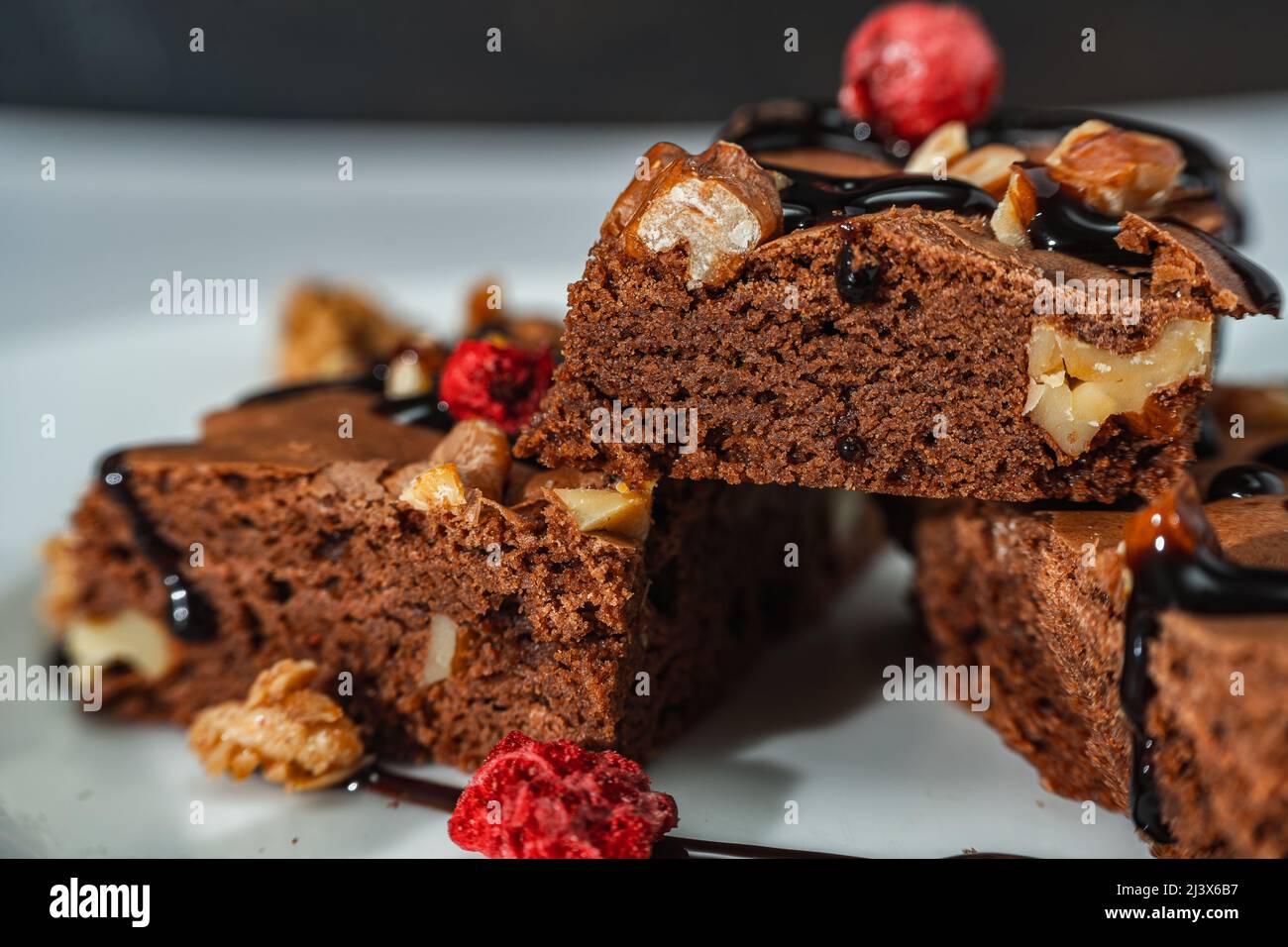 Primo piano di piazze di brownie al cioccolato fatte in casa con pezzi di noce, ciocche di cioccolato e granola. Concetto di cibo naturale e sano. Foto Stock