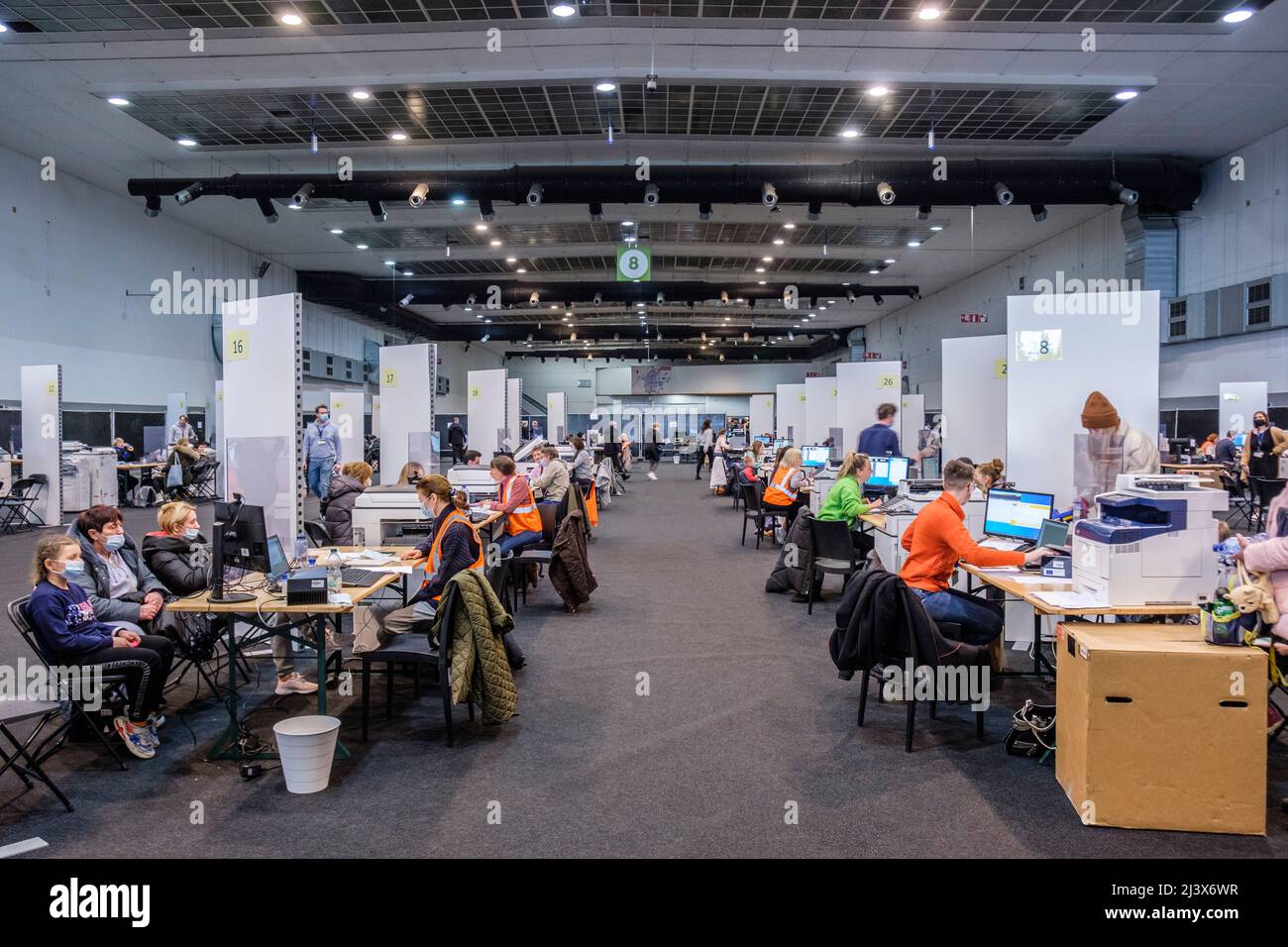 Famiglia, donne, uomini e bambini attendono all'ingresso principale del centro di accoglienza Heyzel per rifugiati - Palais 8 - la gente sta facendo la loro documentazione a Foto Stock