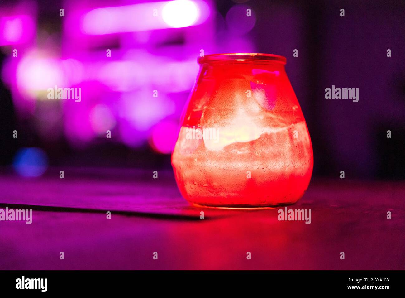 Candela rossa con sfondo viola Foto Stock