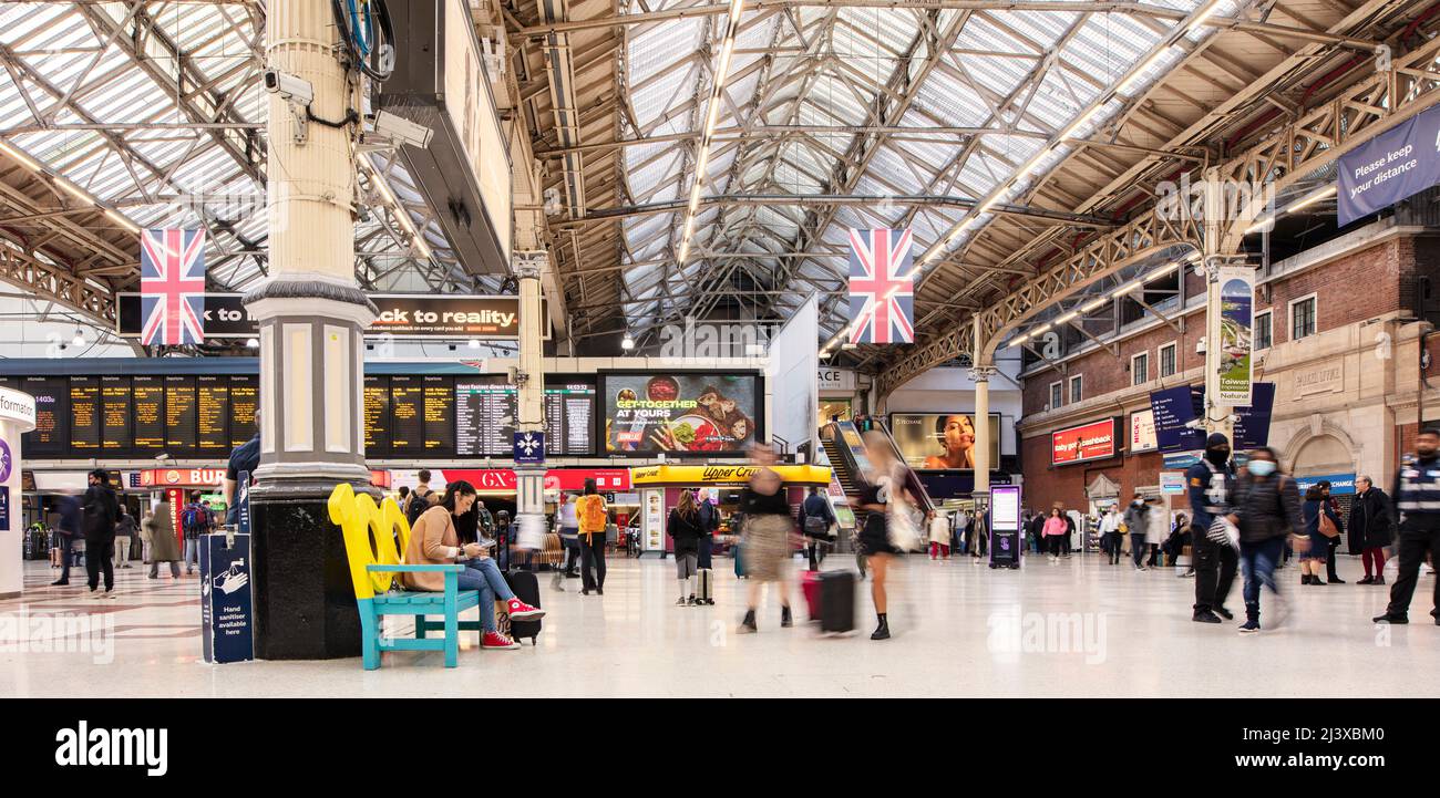 Stazione Victoria di Londra, uno dei principali interscambi ferroviari e metropolitani; una lenta velocità dell'otturatore permette di offuscare le persone all'interno dell'atrio Foto Stock