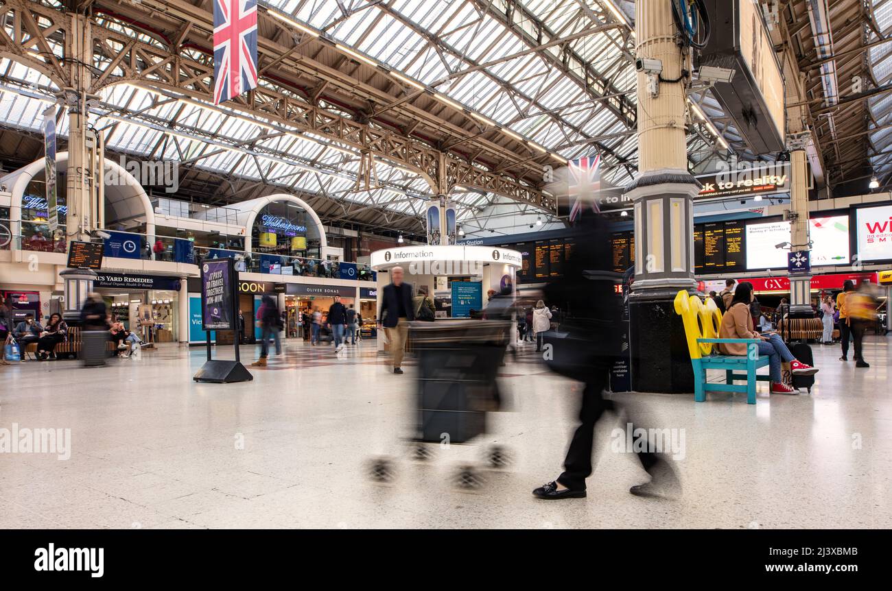 Stazione Victoria di Londra, uno dei principali interscambi ferroviari e metropolitani; una lenta velocità dell'otturatore permette di offuscare le persone all'interno dell'atrio Foto Stock