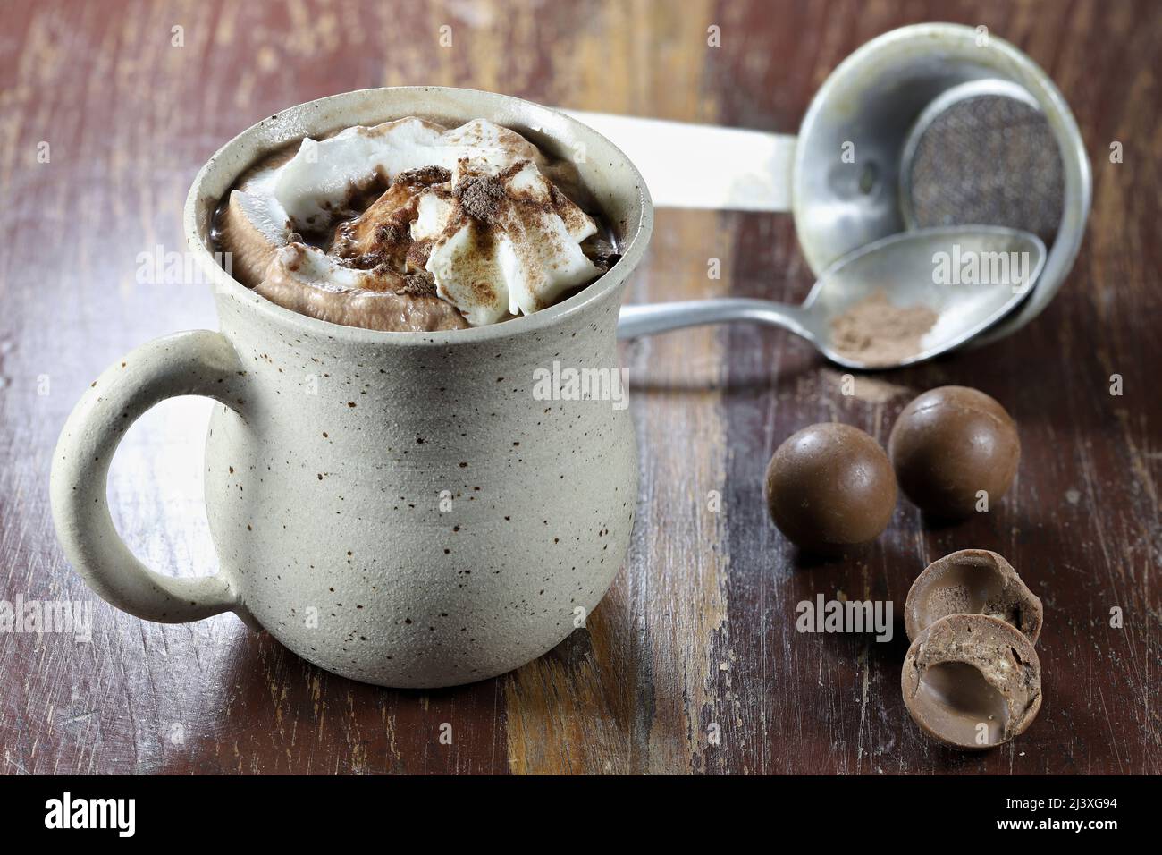 bevanda calda al cioccolato in una tazza fittile su sfondo di legno Foto Stock