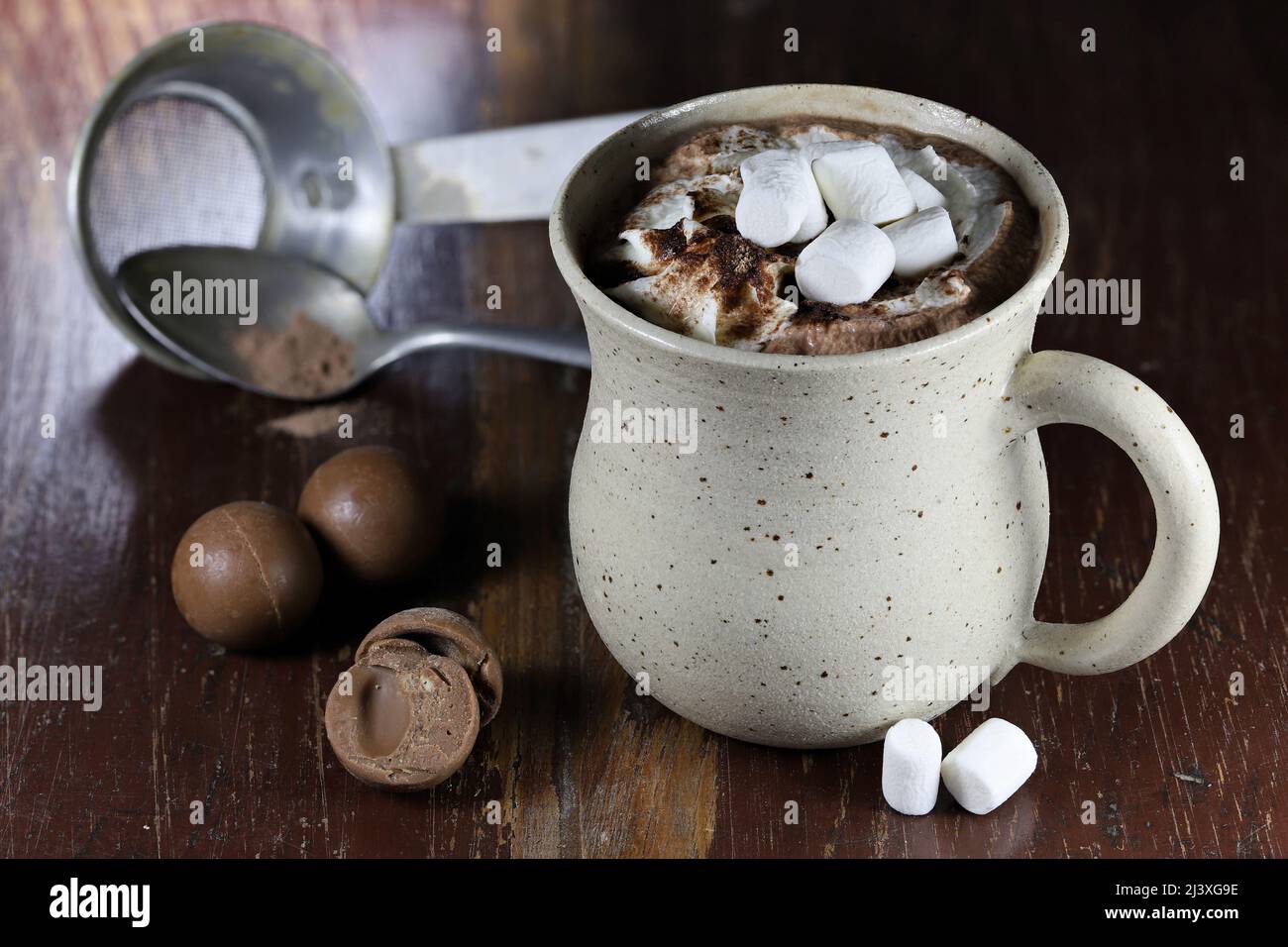 bevanda calda al cioccolato in una tazza fittile su sfondo di legno Foto Stock