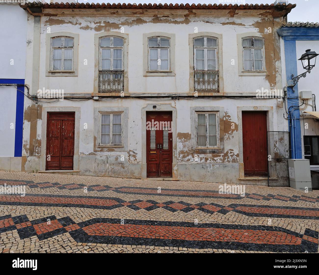 Facciata dipingere sbiadita-porte in legno chiuse-finestre-balconi di vecchia casa cittadina neoclassica. Lagos-Portogallo-210 Foto Stock