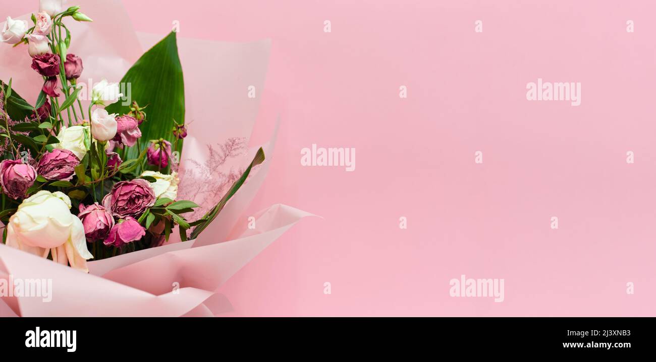 bouquet di fiori morenti su sfondo rosa, fiori morti Foto Stock