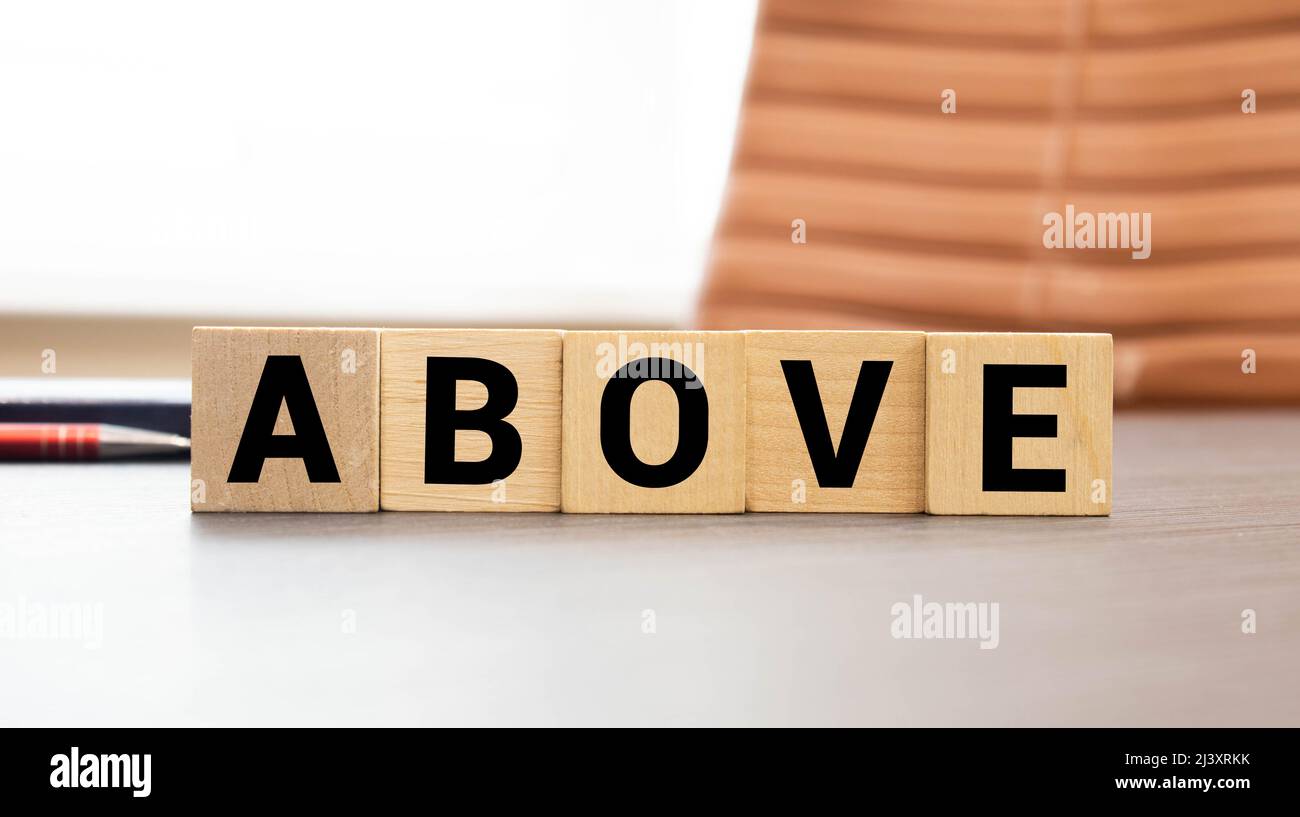 Concetto di antonym sopra e sotto su blocchi di legno Foto Stock