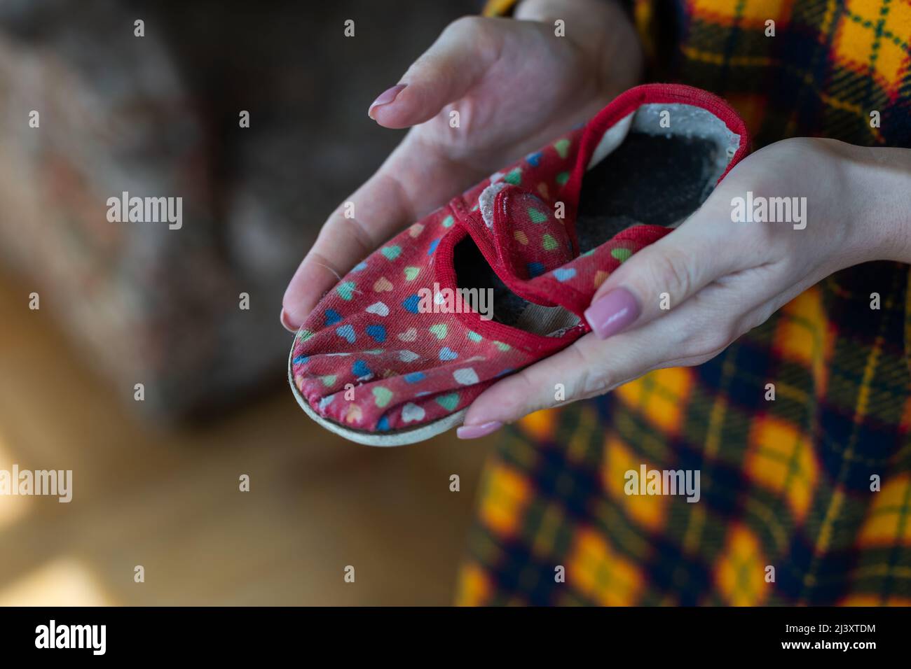 Pantofole per bambini nelle mani delle mamme. Guerra in Ucraina. Foto Stock