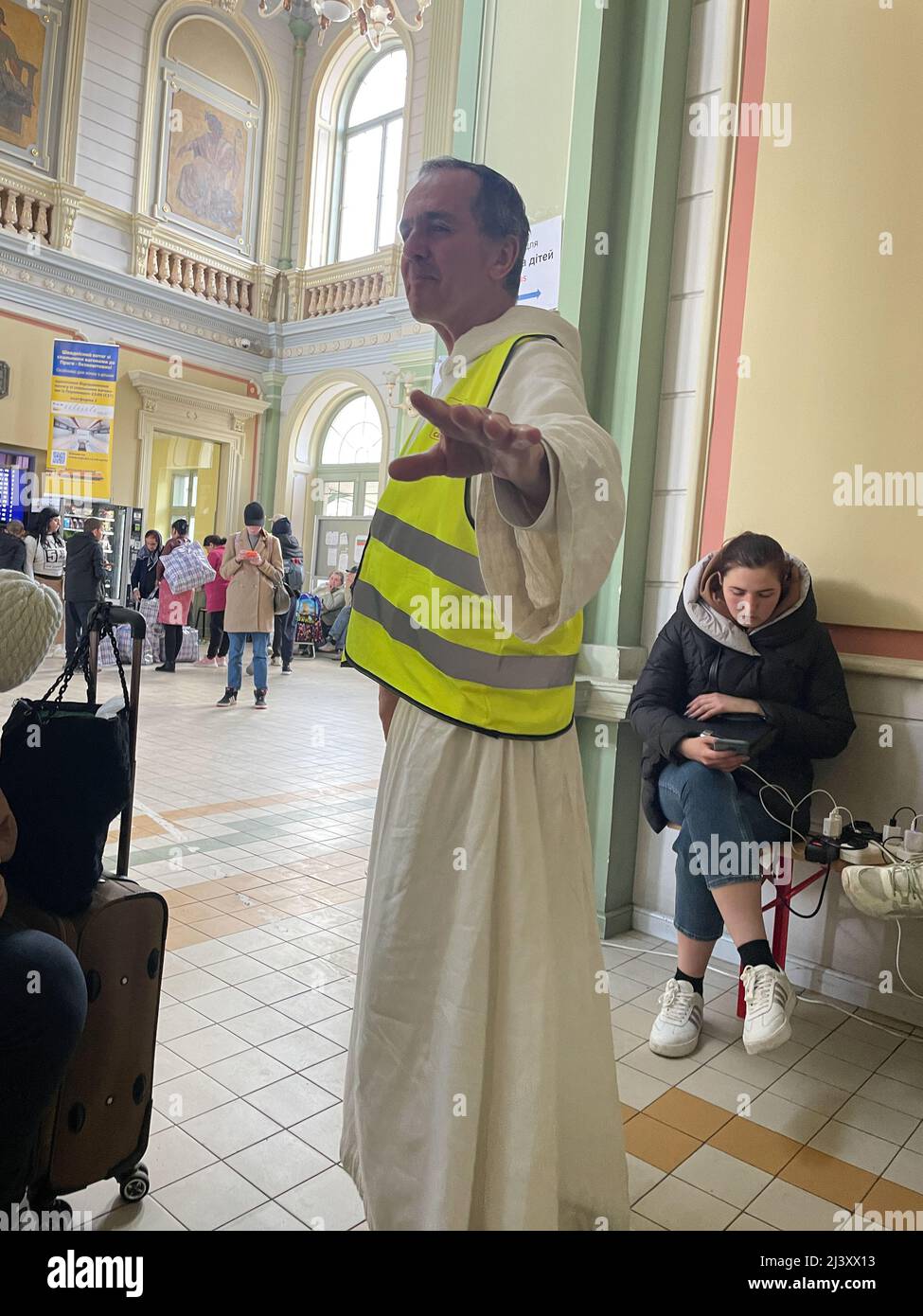 Przemysl, Polonia. 8th Apr 2022. Un sacerdote raggiunge i rifugiati ucraini nella stazione di Przemysl, in Polonia, punto di ingresso per centinaia di migliaia di rifugiati ucraini. Molte organizzazioni cristiane e missionari stanno entrambi fornendo conforto a coloro che nelle loro ore di bisogno aperto ai loro messaggi e ad altri fastidiosi che sono pubblico prigioniero e non vogliono essere convertiti quando stanno cercando appena di fuggire alla sicurezza. (Credit Image: © Amy Katz/ZUMA Press Wire) Foto Stock