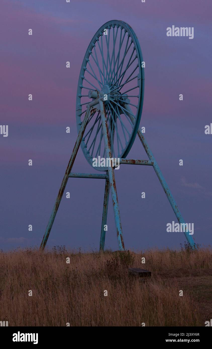 Newcastle-under-Lyme, Staffordshire, 04,08.2022, Apedale pit wheel memoriale e vasca di carbone situato nel parco comunale di Apedale, ex miniera di opencast Foto Stock