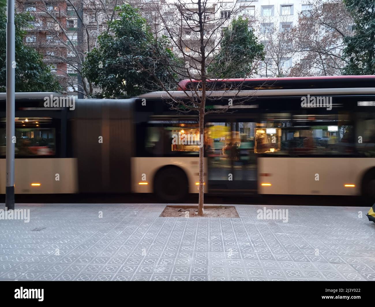 Riflessioni sulle finestre di un autobus in movimento su una strada a Barcellona, Spagna. Foto Stock
