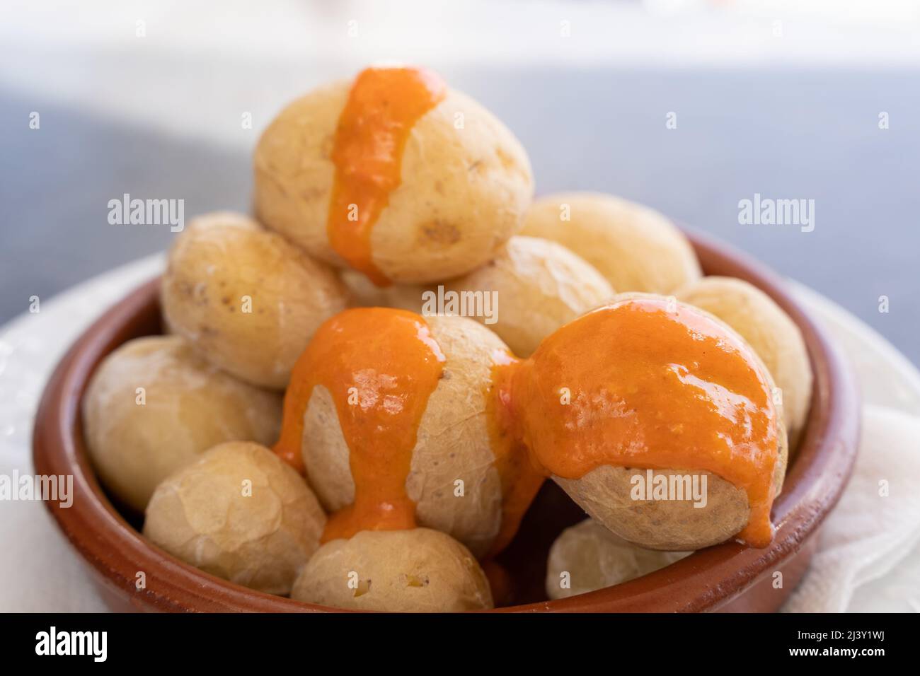 Papas arrugadas in piatto di argilla e salsa mojo piccante in cima. Tradizionale rughe patate snack cibo da Gran Canaria isola, Spagna Foto Stock