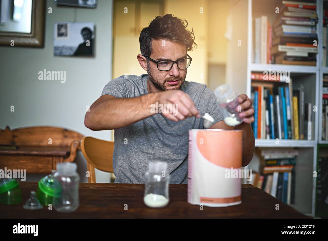 HES imparare ogni giorno. Scatto corto di un singolo padre che prepara un biberon per il suo bambino a casa. Foto Stock