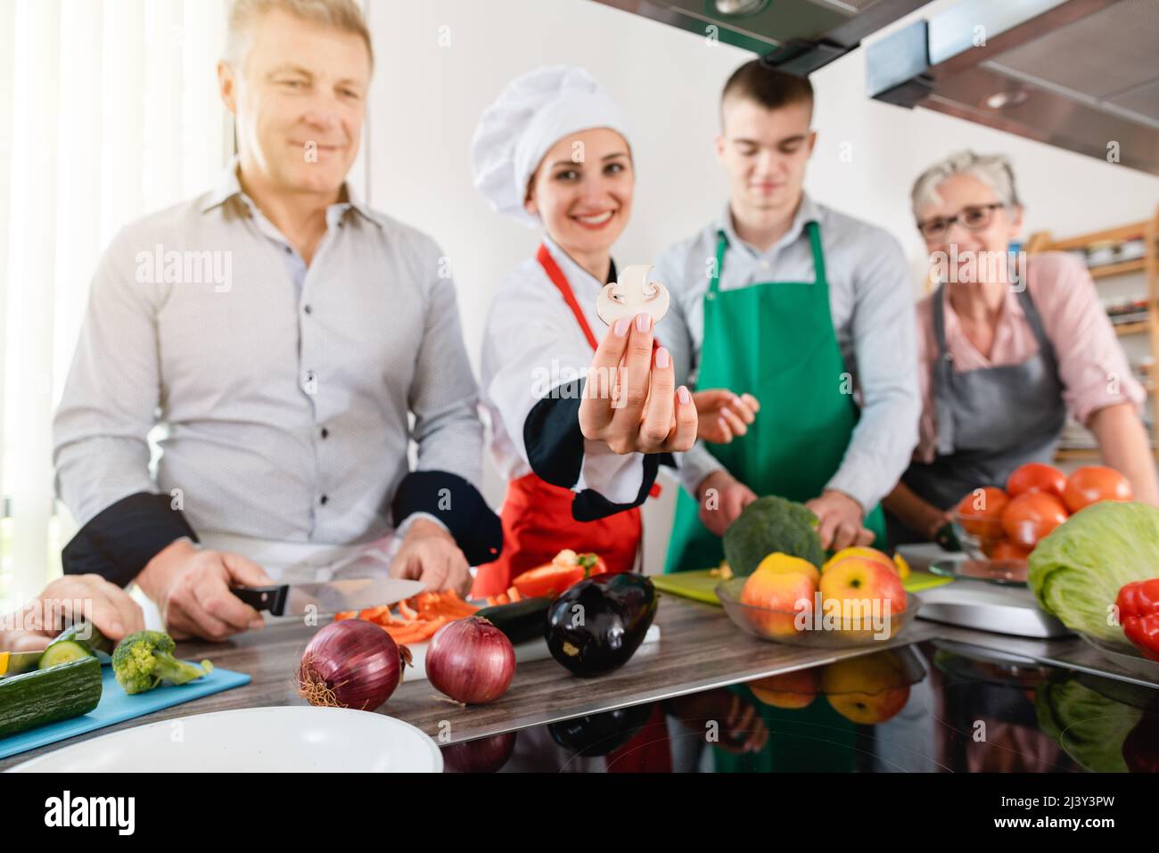 Dietista che mostra ai suoi apprendisti come cucinare in modo sano Foto Stock